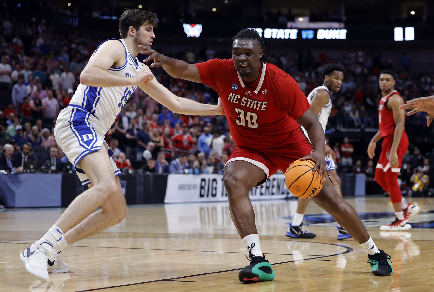 DALLAS, TEXAS - MARCH 31:  DJ Burns Jr. #30 of the North Carolina State Wolfpack controls the ball as Ryan Young #15 of the Duke Blue Devils defends in the Elite 8 round of the NCAA Men's Basketball Tournament at American Airlines Center on March 31, 2024 in Dallas, Texas. (Photo by Carmen Mandato/Getty Images)