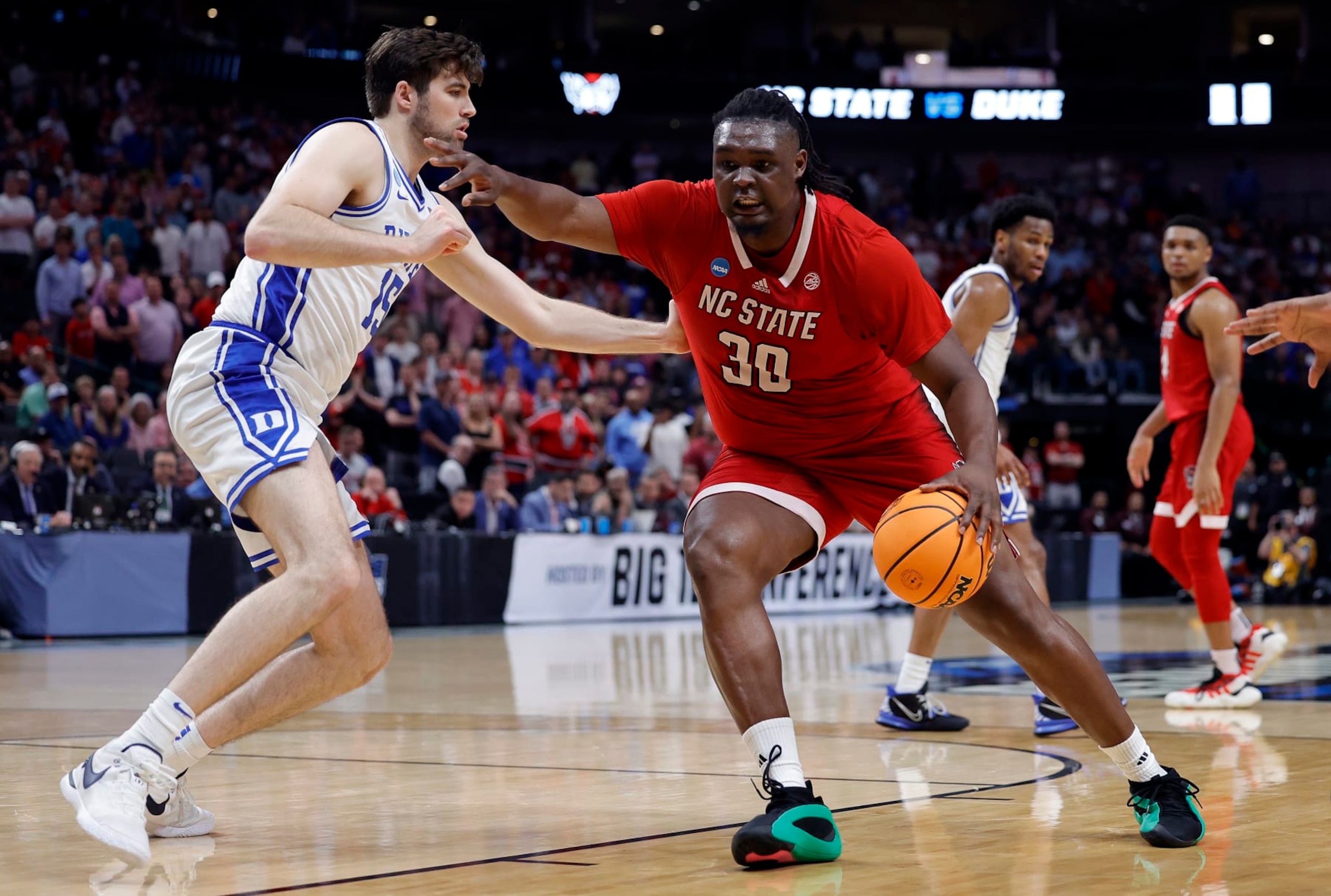 DALLAS, TEXAS - MARCH 31:  DJ Burns Jr. #30 of the North Carolina State Wolfpack controls the ball as Ryan Young #15 of the Duke Blue Devils defends in the Elite 8 round of the NCAA Men's Basketball Tournament at American Airlines Center on March 31, 2024 in Dallas, Texas. (Photo by Carmen Mandato/Getty Images)