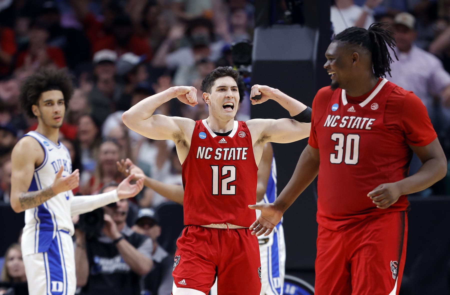 DALLAS, TEXAS - MARCH 31:  Michael O'Connell #12 of the North Carolina State Wolfpack and DJ Burns Jr. #30 of the North Carolina State Wolfpack react after drawing a foul in the second half of the Elite 8 round of the NCAA Men's Basketball Tournament against the Duke Blue Devils at American Airlines Center on March 31, 2024 in Dallas, Texas. (Photo by Carmen Mandato/Getty Images)