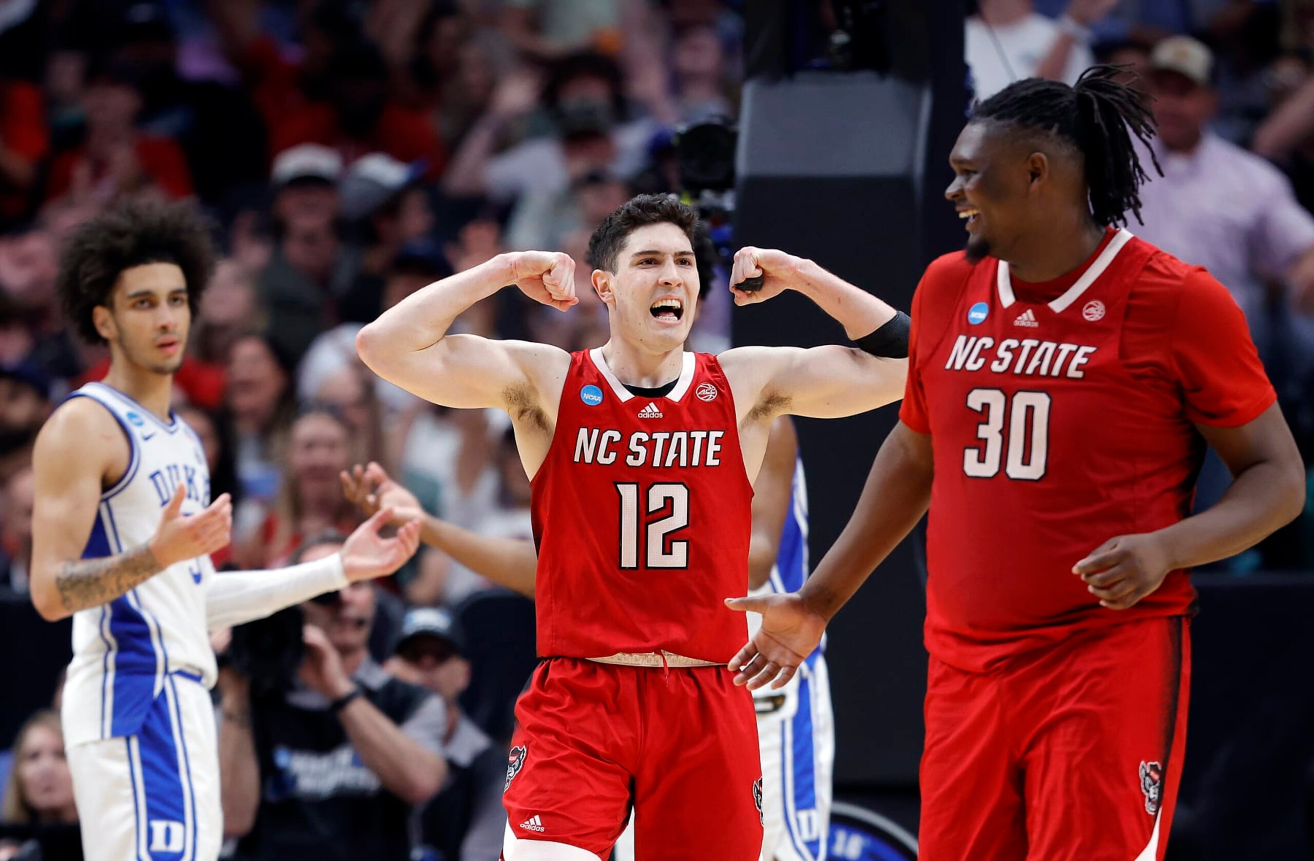 DALLAS, TEXAS - MARCH 31:  Michael O'Connell #12 of the North Carolina State Wolfpack and DJ Burns Jr. #30 of the North Carolina State Wolfpack react after drawing a foul in the second half of the Elite 8 round of the NCAA Men's Basketball Tournament against the Duke Blue Devils at American Airlines Center on March 31, 2024 in Dallas, Texas. (Photo by Carmen Mandato/Getty Images)