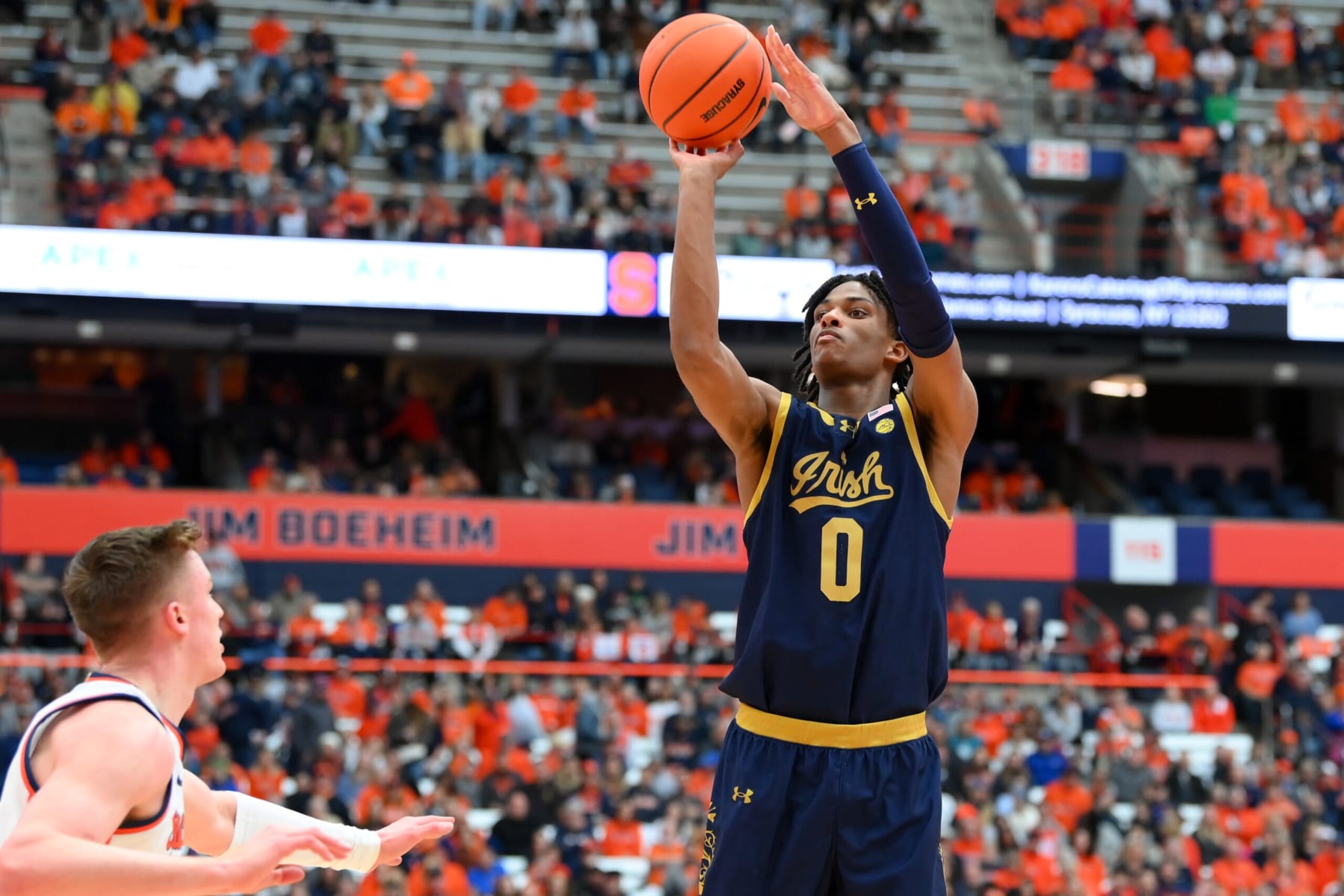 SYRACUSE, NEW YORK - FEBRUARY 24: Carey Booth #0 of the Notre Dame Fighting Irish shoots the ball as Justin Taylor #5 of the Syracuse Orange defends during the first half at the JMA Wireless Dome on February 24, 2024 in Syracuse, New York. (Photo by Rich Barnes/Getty Images) SYRACUSE, NEW YORK - FEBRUARY 24: Carey Booth #0 of the Notre Dame Fighting Irish shoots the ball as Justin Taylor #5 of the Syracuse Orange defends during the first half at the JMA Wireless Dome on February 24, 2024 in Syracuse, New York. (Photo by Rich Barnes/Getty Images)