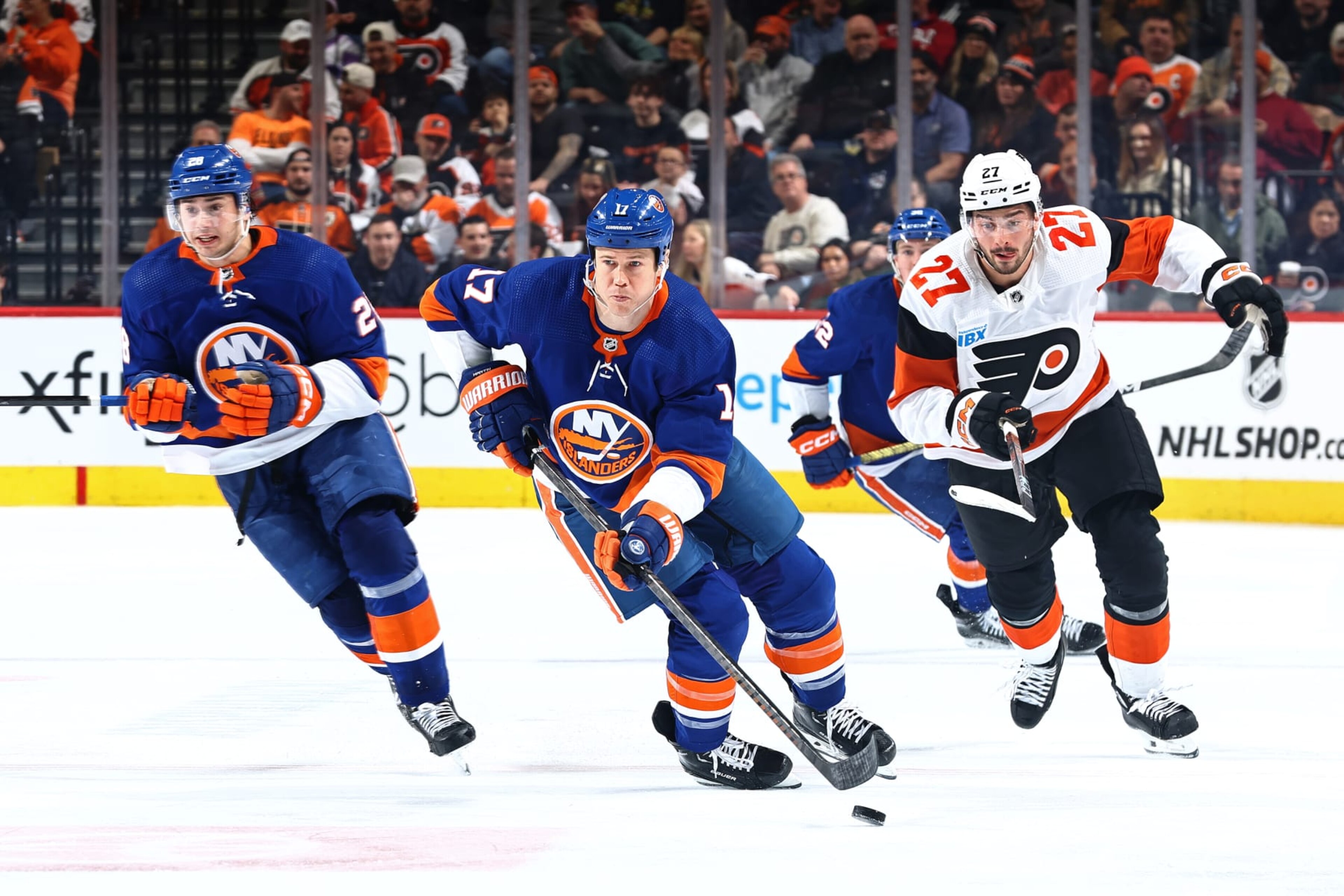 PHILADELPHIA, PENNSYLVANIA - APRIL 01: Matt Martin #17 of the New York Islanders skates with the puck past Noah Cates #27 of the Philadelphia Flyers during the third period at the Wells Fargo Center on April 01, 2024 in Philadelphia, Pennsylvania. (Photo by Tim Nwachukwu/Getty Images)
