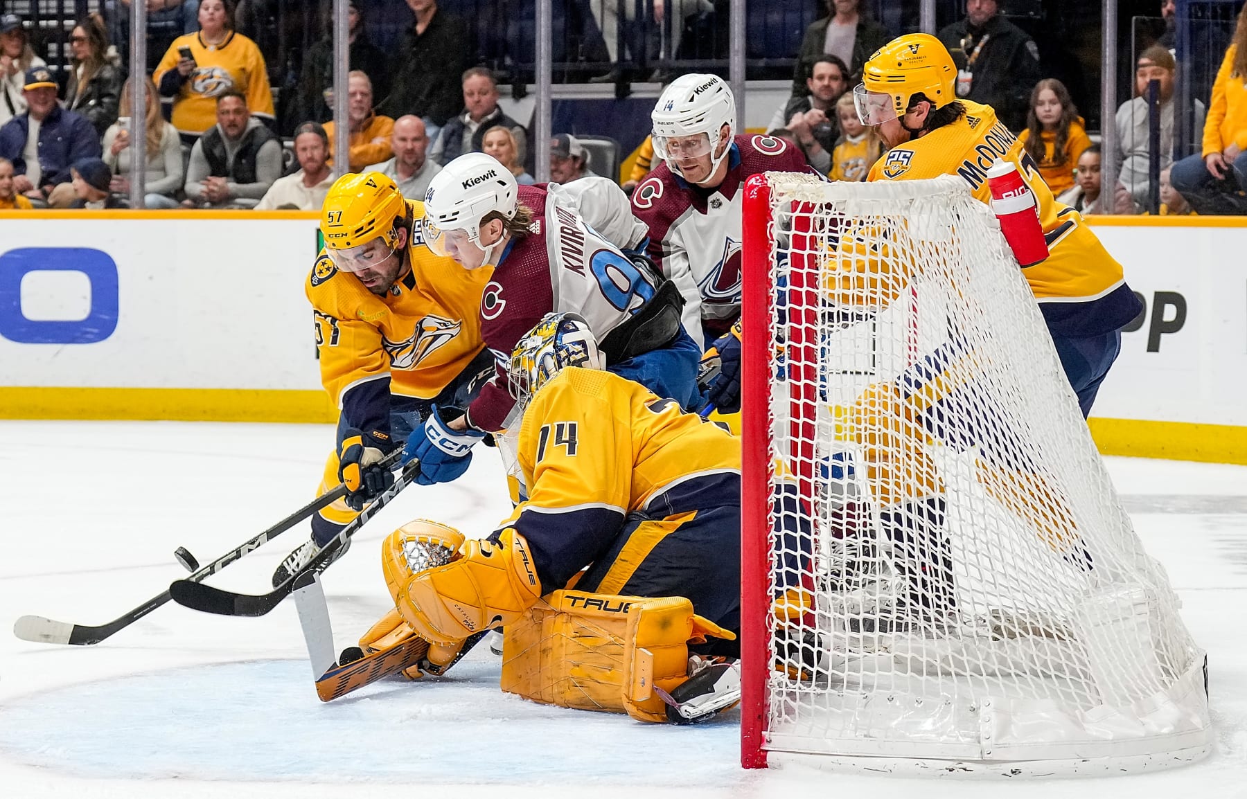 NASHVILLE, TENNESSEE - MARCH 2: Joel Kiviranta #94 of the Colorado Avalanche battles for the puck in front of the net against Dante Fabbro #57 and Juuse Saros #74 of the Nashville Predators during an NHL game at Bridgestone Arena on March 2, 2024 in Nashville, Tennessee. (Photo by John Russell/NHLI via Getty Images)