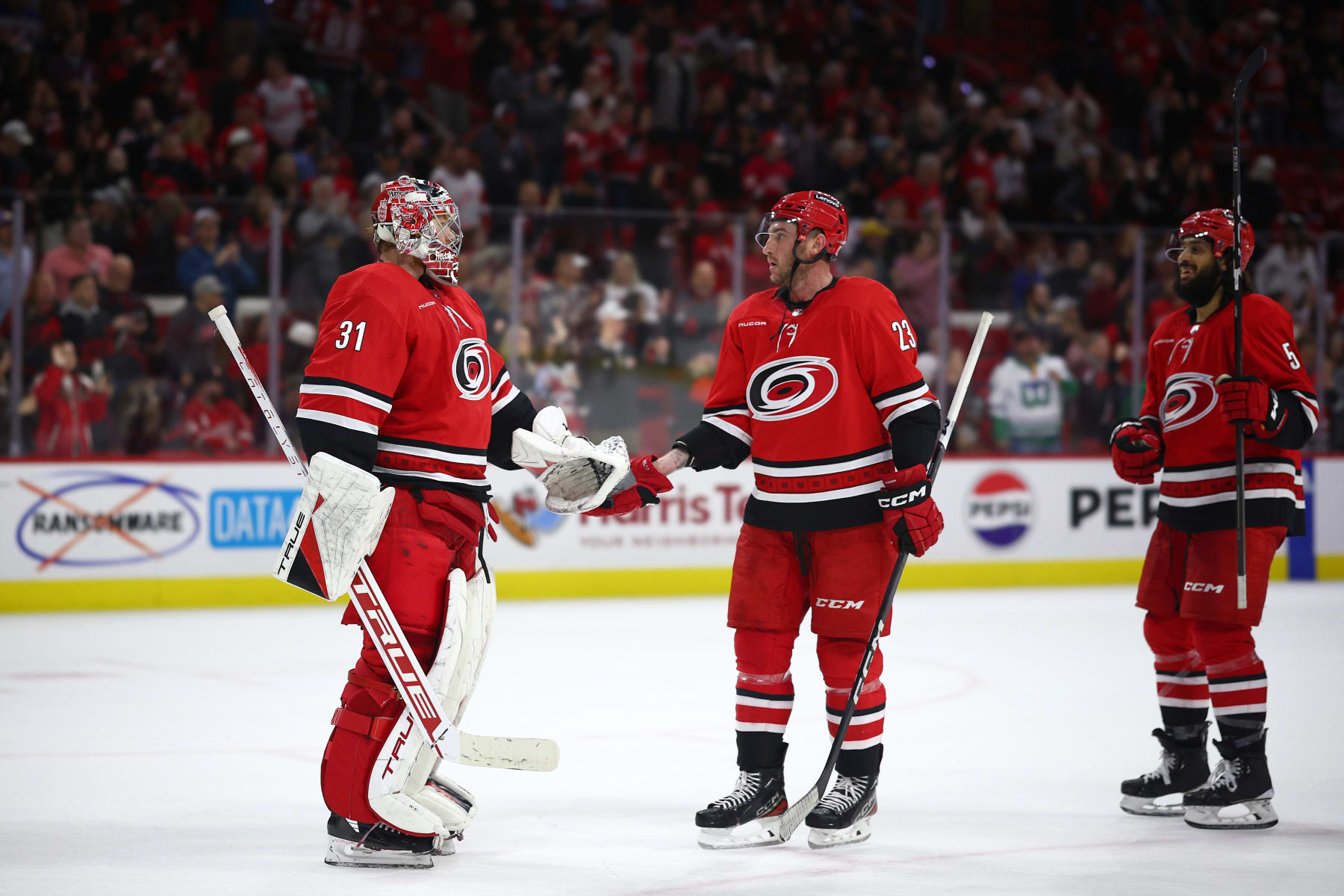 RALEIGH, NORTH CAROLINA - MARCH 28: Stefan Noesen #23 of the Carolina Hurricanes is congratulated by teammates following the third period of the game against the Detroit Red Wings at PNC Arena on March 28, 2024 in Raleigh, North Carolina. (Photo by Jared C. Tilton/Getty Images)