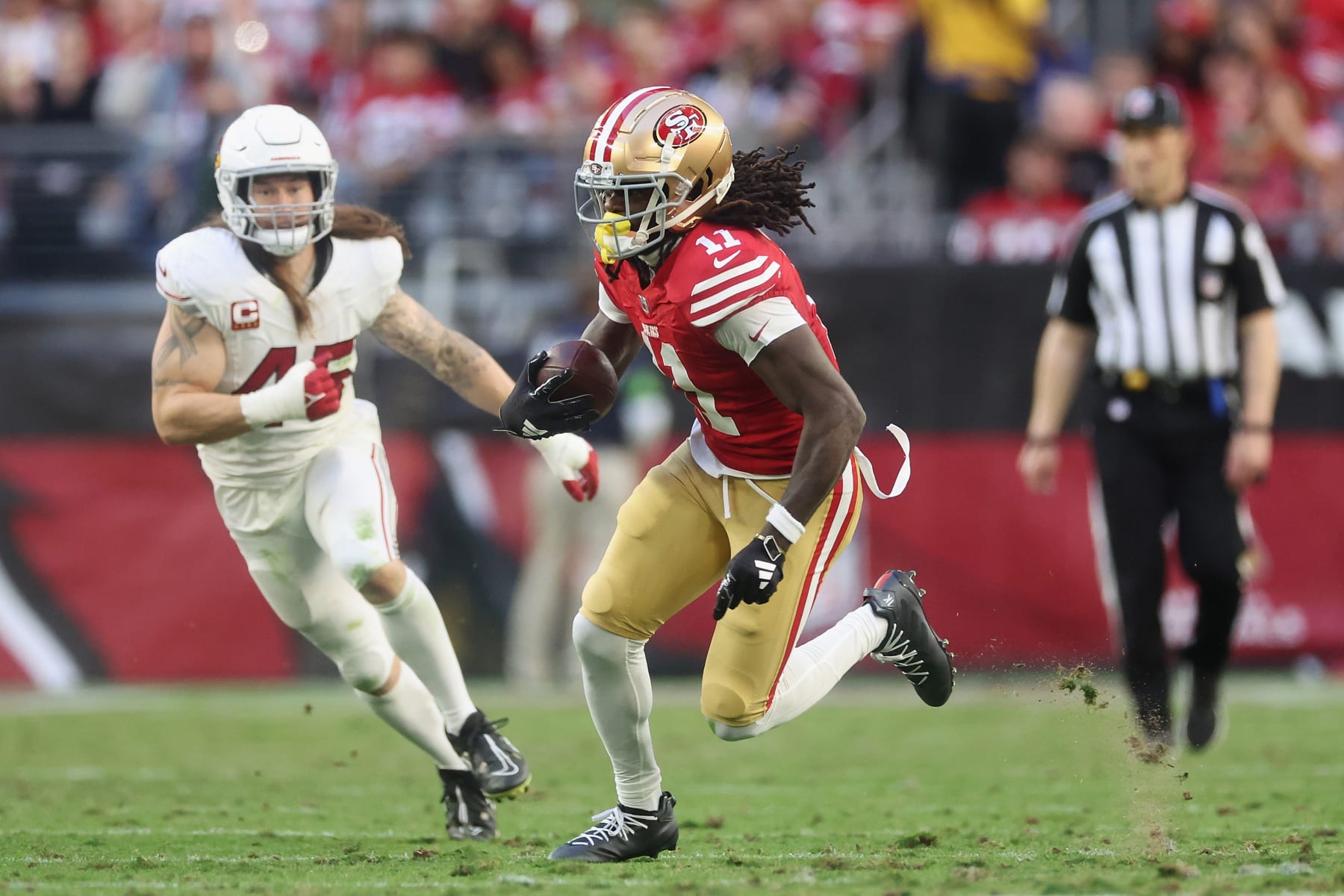 GLENDALE, ARIZONA - DECEMBER 17: Wide receiver Brandon Aiyuk #11 of the San Francisco 49ers makes a reception past linebacker Dennis Gardeck #45 of the Arizona Cardinals during the NFL game at State Farm Stadium on December 17, 2023 in Glendale, Arizona. The 49ers defeated the Cardinals 45-29.  (Photo by Christian Petersen/Getty Images)