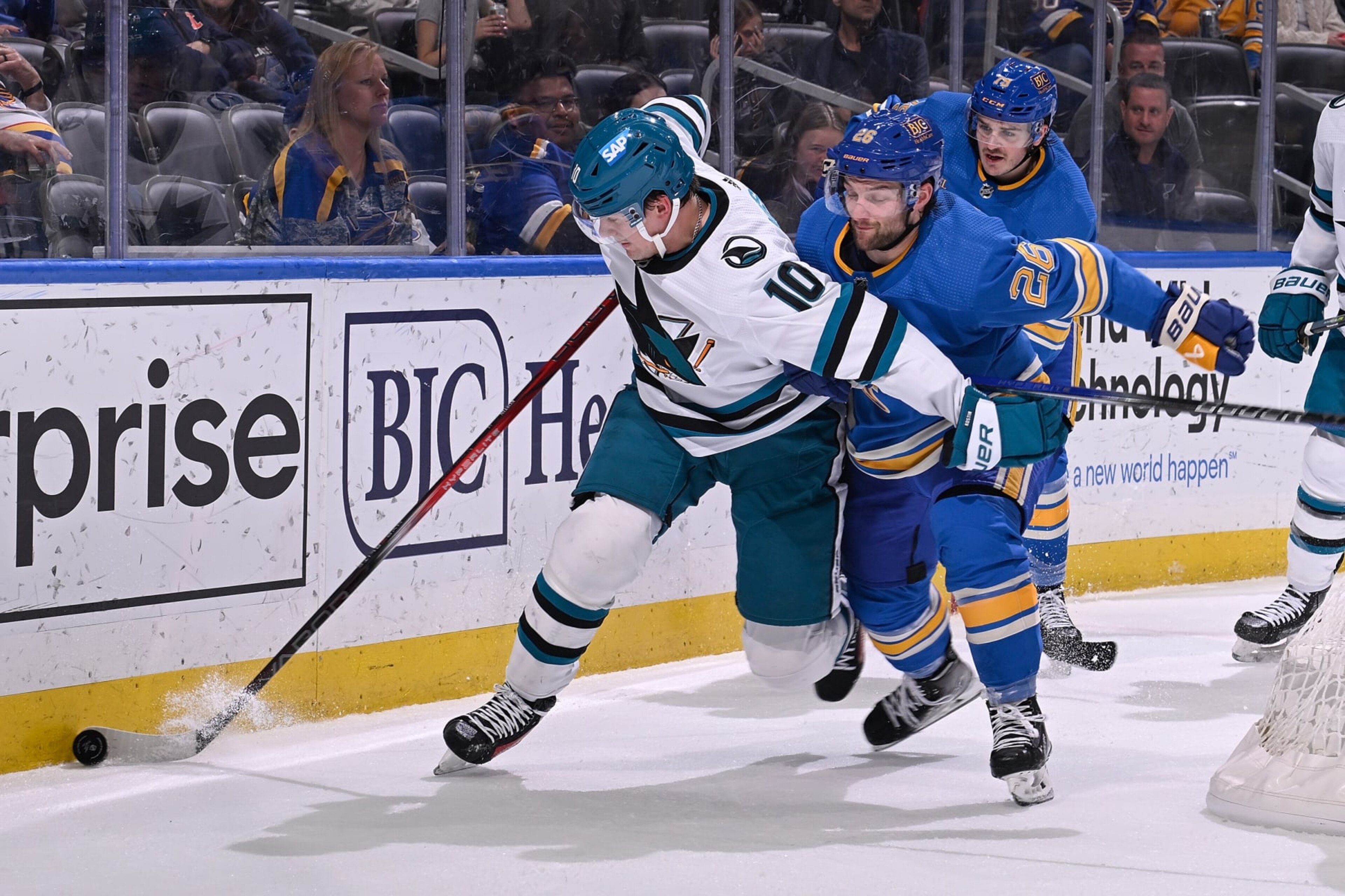 ST. LOUIS, MO - MARCH 30: Nathan Walker #26 of the St. Louis Blues battles Klim Kostin #10 of the San Jose Sharks for the puck on March 30, 2024 at the Enterprise Center in St. Louis, Missouri. (Photo by Joe Puetz/NHLI via Getty Images)