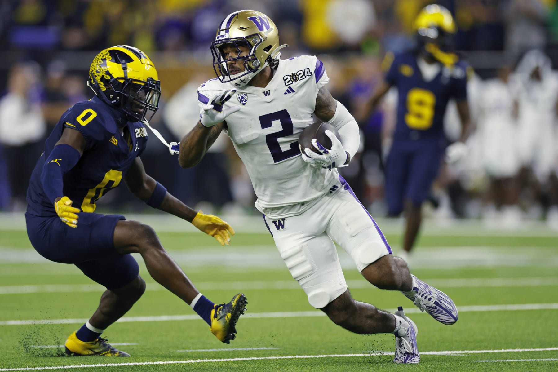 HOUSTON, TX - JANUARY 08: Washington Huskies wide receiver Ja'Lynn Polk (2) runs with the ball after a catch against Michigan Wolverines defensive back Mike Sainristil (0) during the CFP National Championship on January 08, 2024 at NRG Stadium in Houston, Texas. (Photo by Joe Robbins/Icon Sportswire via Getty Images)