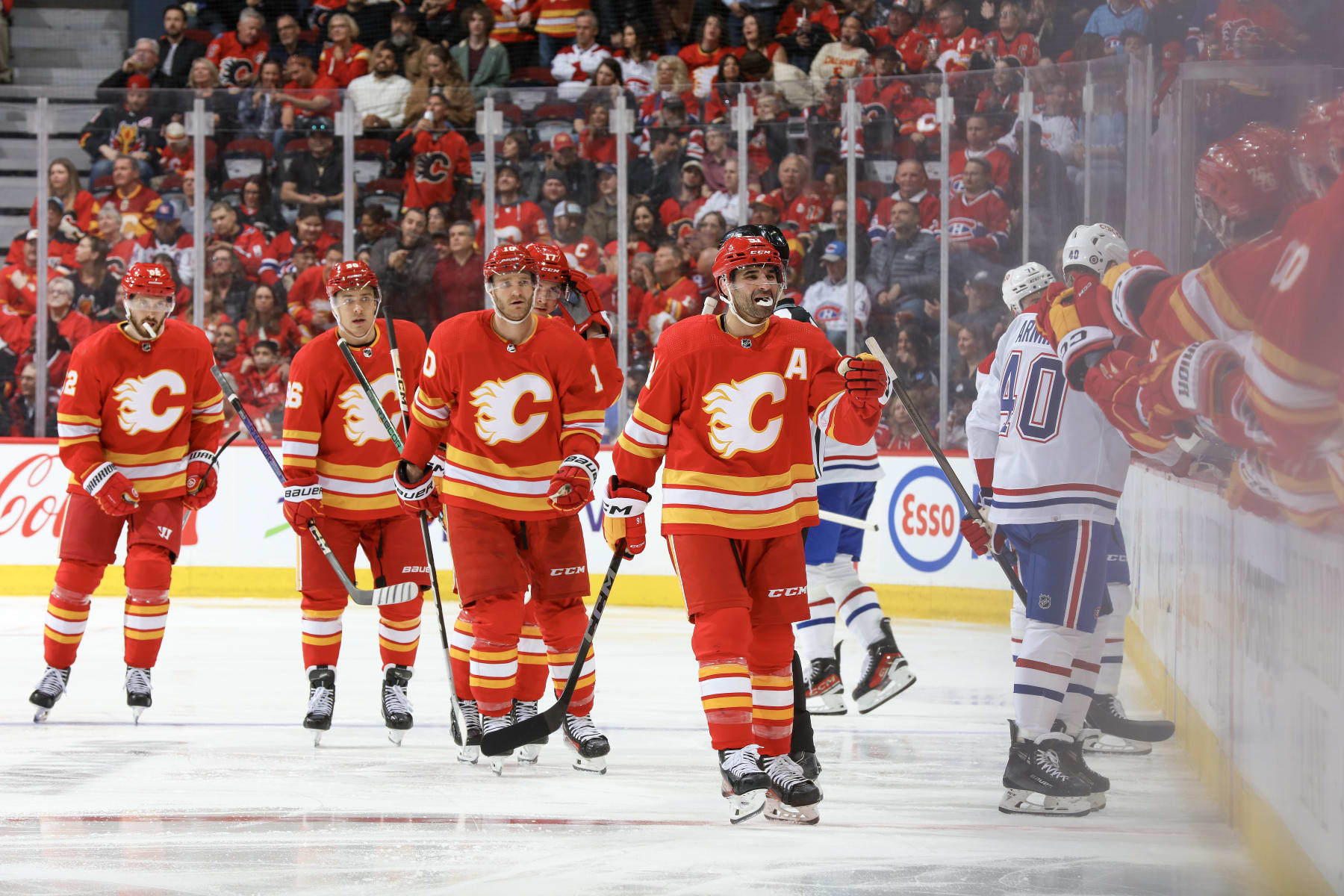 CALGARY, ALBERTA - MARCH 16: Nazem Kadri #91, Jonathan Huberdeau #10 and teammates of the Calgary Flames celebrate a go against the Montreal Canadiens at the Scotiabank Saddledome on March 16, 2024 in Calgary, Alberta. (Photo by Gerry Thomas/NHLI via Getty Images)