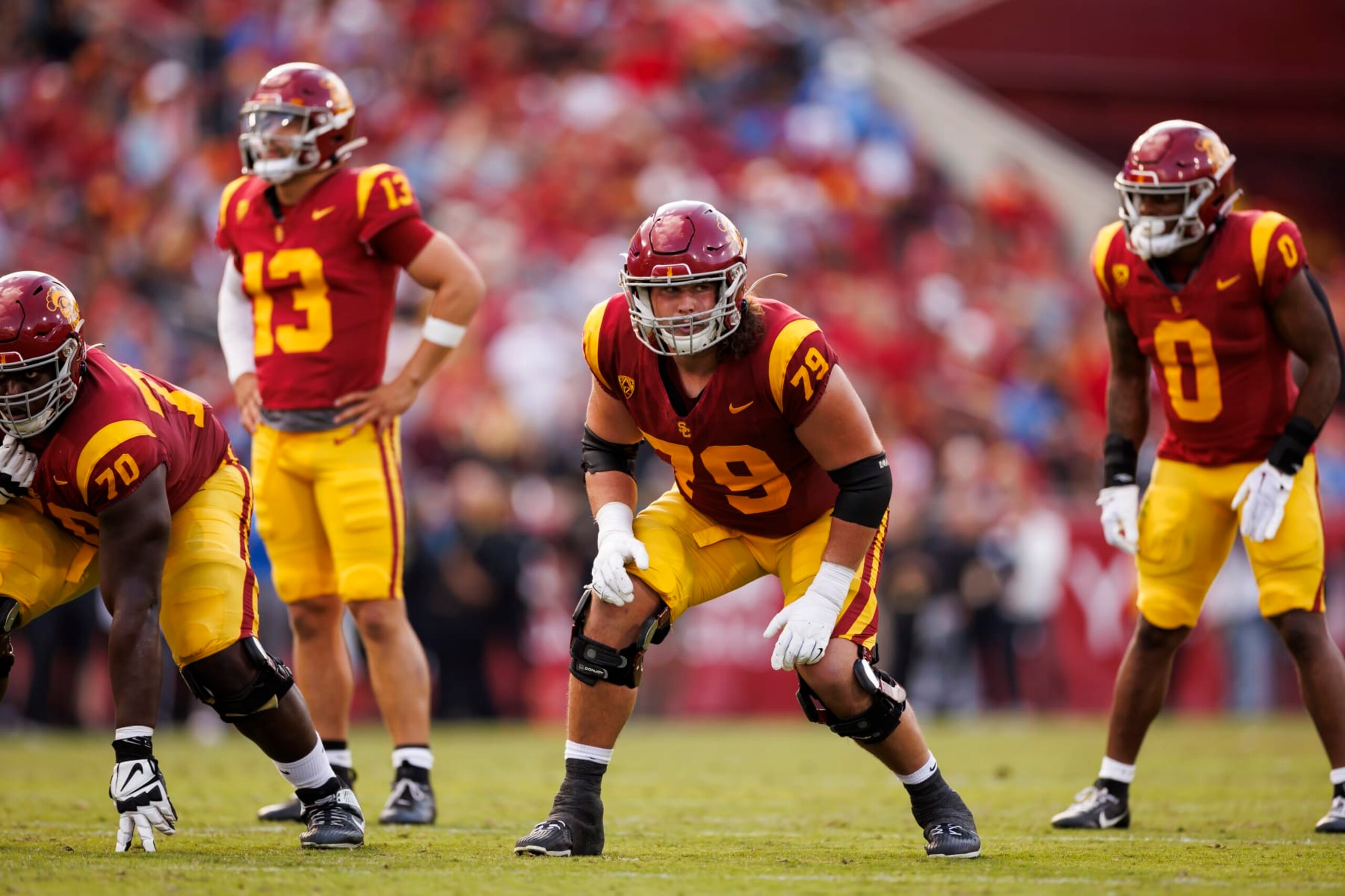 LOS ANGELES, CALIFORNIA - NOVEMBER 18: Jonah Monheim #79 of the USC Trojans gets set to block during the first half of a game against the UCLA Bruins at United Airlines Field at the Los Angeles Memorial Coliseum on November 18, 2023 in Los Angeles, California. (Photo by Ryan Kang/Getty Images)