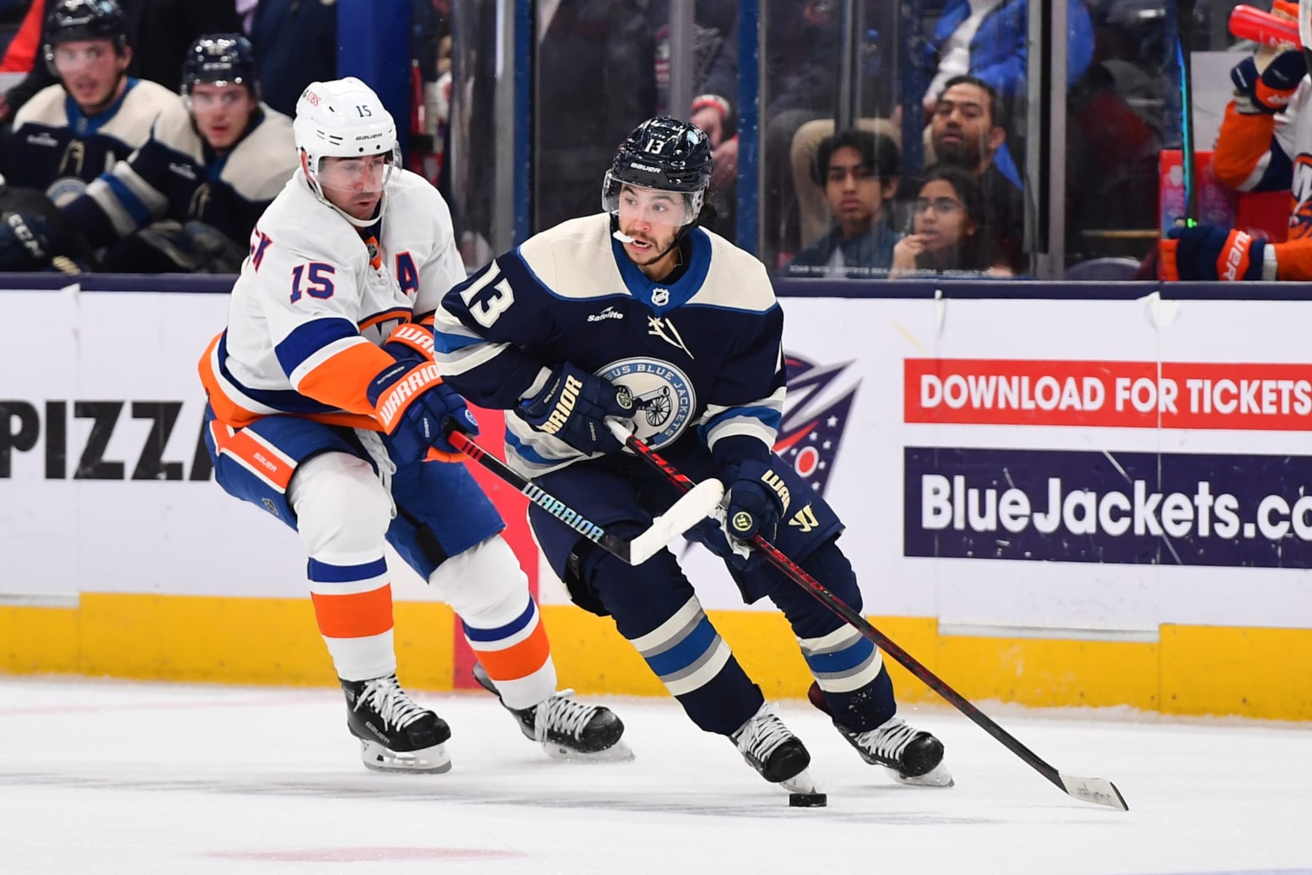 COLUMBUS, OHIO - OCTOBER 28: Johnny Gaudreau #13 of the Columbus Blue Jackets skates with the puck as Cal Clutterbuck #15 of the New York Islanders defends during the second period of a game at Nationwide Arena on October 28, 2023 in Columbus, Ohio. (Photo by Ben Jackson/NHLI via Getty Images)