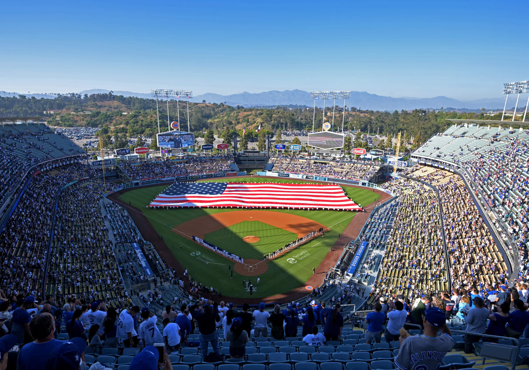 LOS ANGELES, CALIFORNIA - JULY 4: An American flag is held by members of the military during the National Anthem prior to the game between the Los Angeles Dodgers and the Pittsburgh Pirates at Dodger Stadium on July 4, 2023 in Los Angeles, California. (Photo by Jayne Kamin-Oncea/Getty Images)