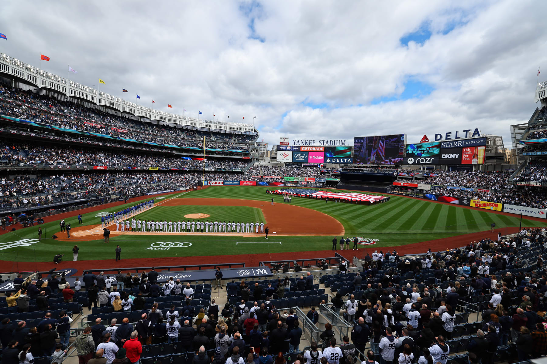 BRONX, NY - APRIL 05:  A general view of a large American Flag and the New York Yankees and Toronto Blue Jays lined up during the National Anthem on April 5, 2024 at Yankee Stadium in the Bronx, New York.  (Photo by Rich Graessle/Icon Sportswire via Getty Images)