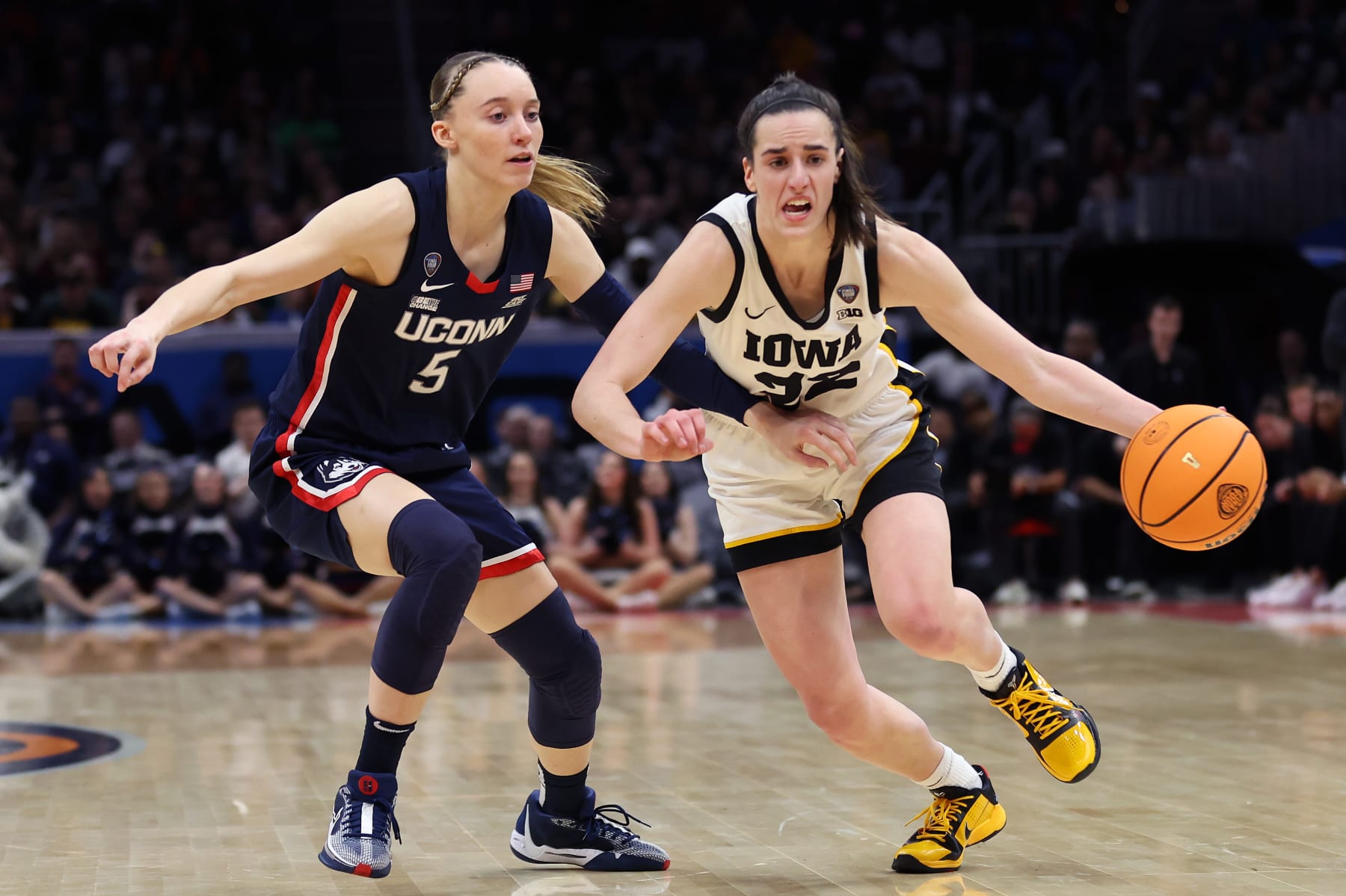 CLEVELAND, OHIO - APRIL 05: Caitlin Clark #22 of the Iowa Hawkeyes dribbles around Paige Bueckers #5 of the UConn Huskies in the second half during the NCAA Women's Basketball Tournament Final Four semifinal game at Rocket Mortgage Fieldhouse on April 05, 2024 in Cleveland, Ohio. (Photo by Steph Chambers/Getty Images)