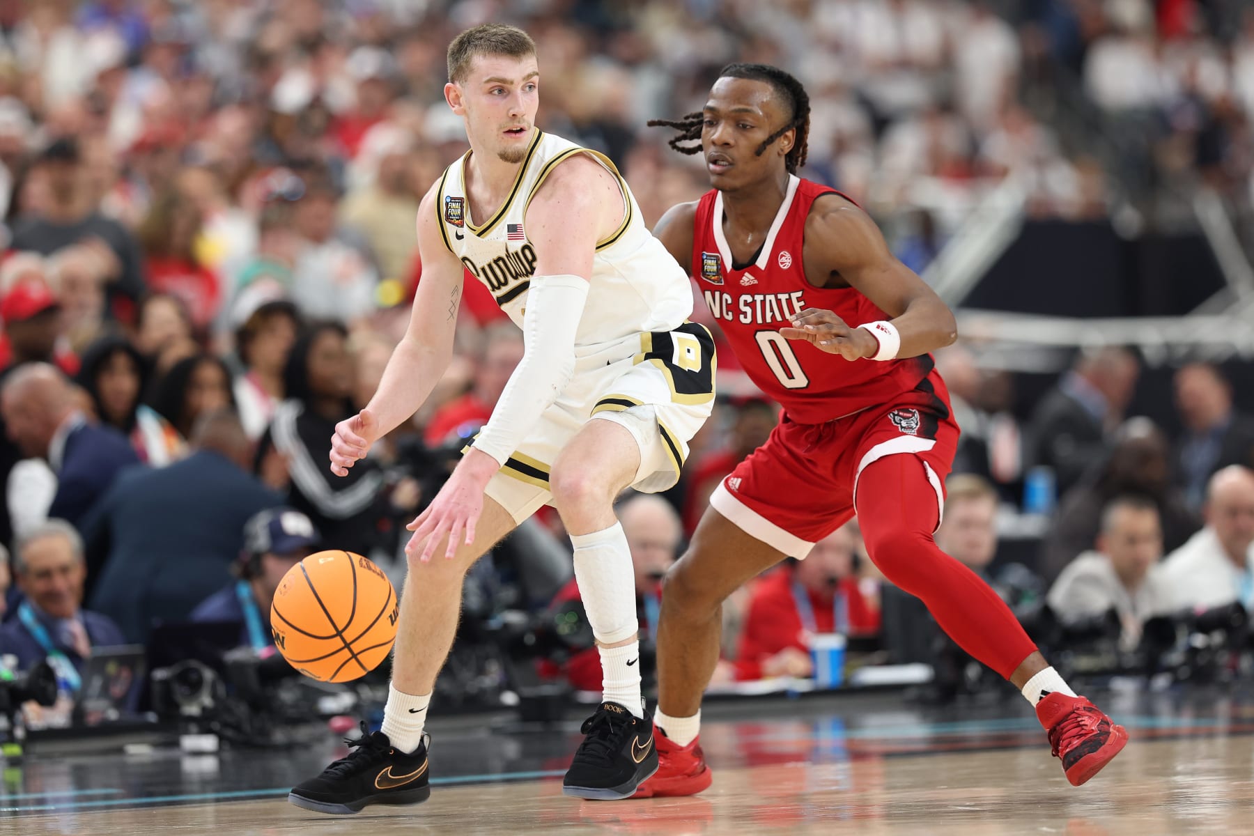 GLENDALE, ARIZONA - APRIL 06: Braden Smith #3 of the Purdue Boilermakers dribbles the ball while being guarded by DJ Horne #0 of the North Carolina State Wolfpack in the first half in the NCAA Men's Basketball Tournament Final Four semifinal game at State Farm Stadium on April 06, 2024 in Glendale, Arizona. (Photo by Jamie Squire/Getty Images)
