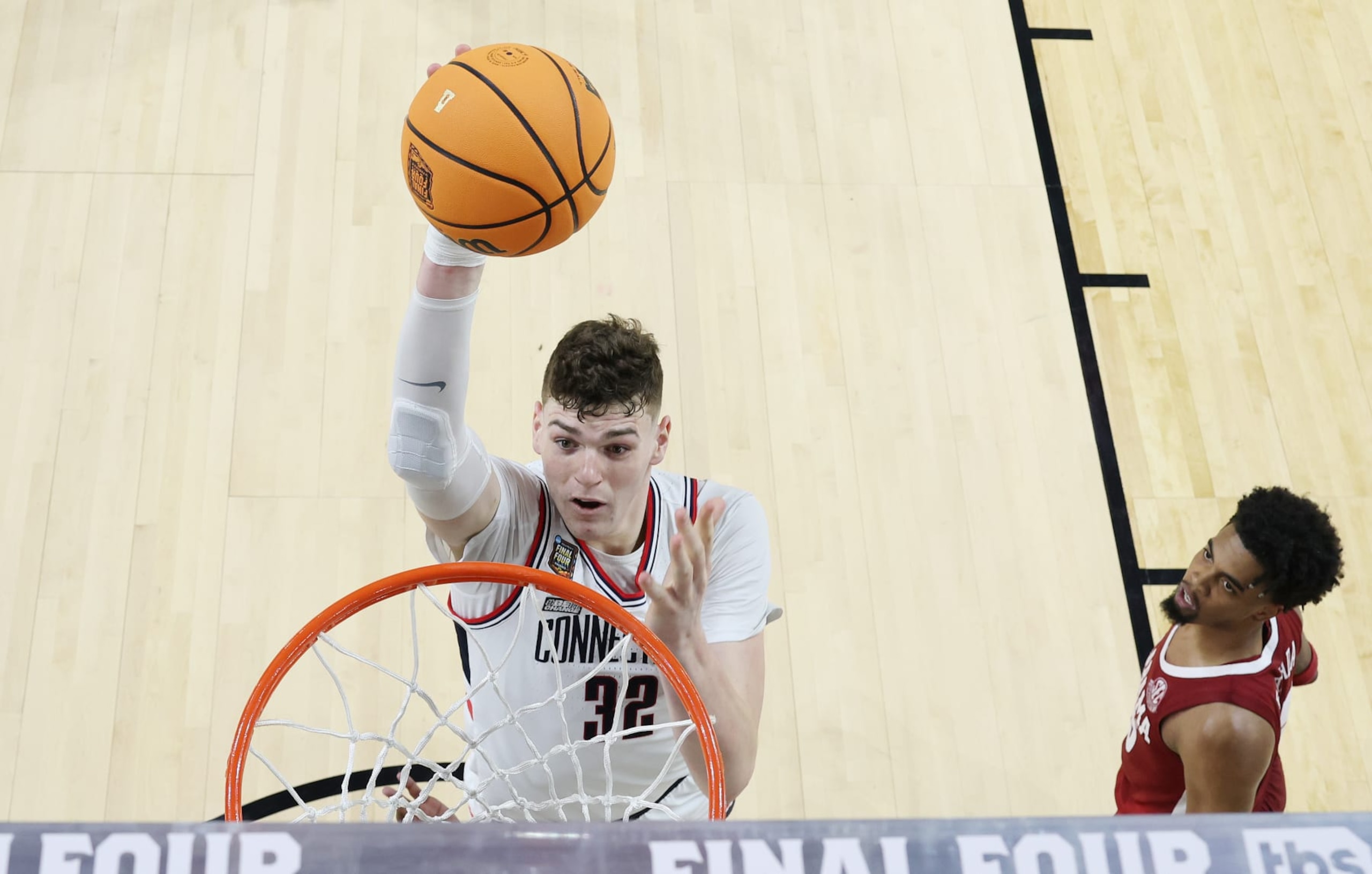 GLENDALE, ARIZONA - APRIL 06: (EDITORS NOTE: Image taken using a remote camera.) Donovan Clingan #32 of the Connecticut Huskies dunk during the first half in the NCAA Men’s Basketball Tournament Final Four semifinal game against the Alabama Crimson Tide at State Farm Stadium on April 06, 2024 in Glendale, Arizona. (Photo by Brett Wilhelm/NCAA Photos via Getty Images)