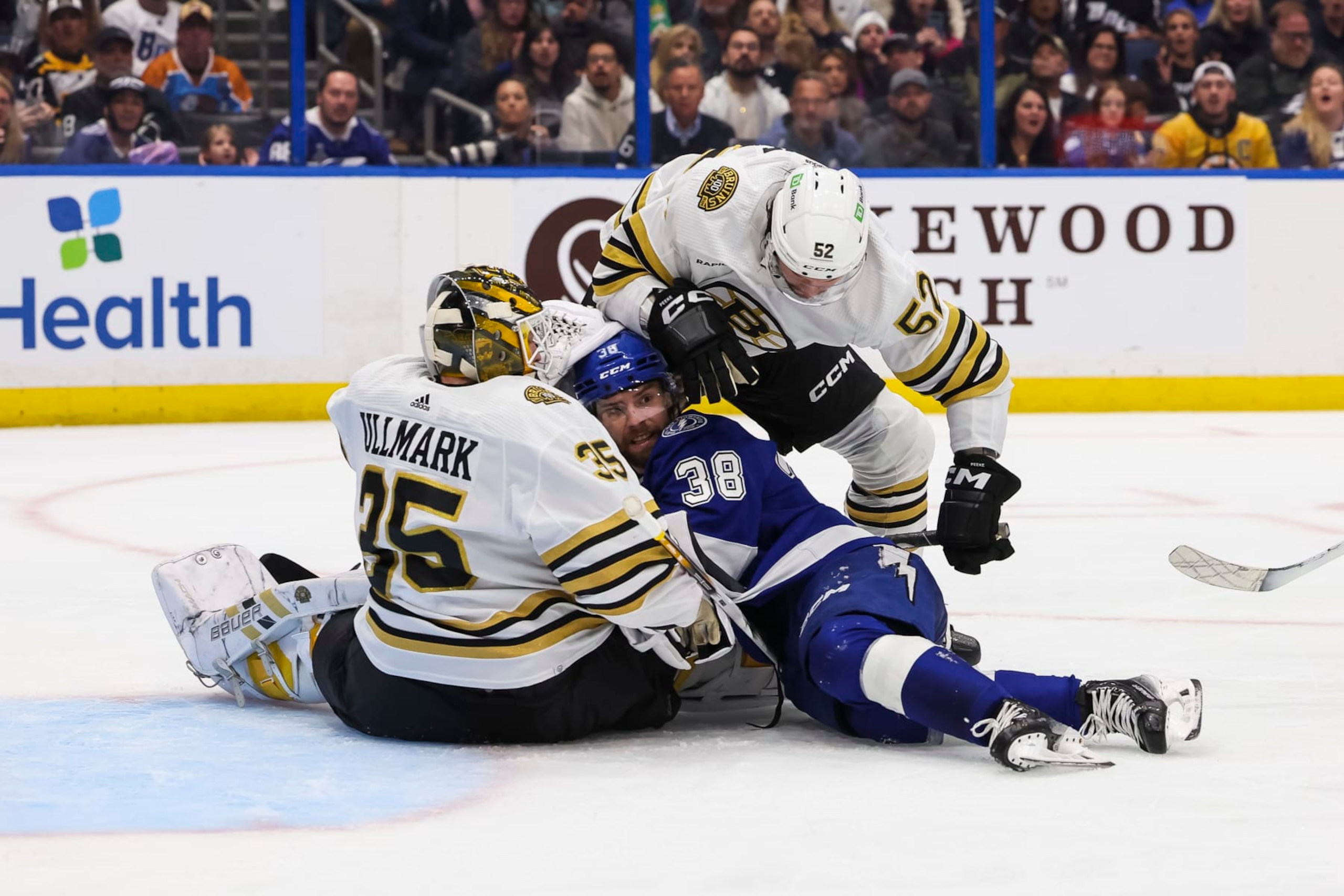 TAMPA, FL - MARCH 27: Brandon Hagel #38 of the Tampa Bay Lightning against is pinned between goalie Linus Ullmark #35 and Andrew Peeke #52 of the Boston Bruins during the third period at Amalie Arena on March 27, 2024 in Tampa, Florida. (Photo by Mark LoMoglio/NHLI via Getty Images)