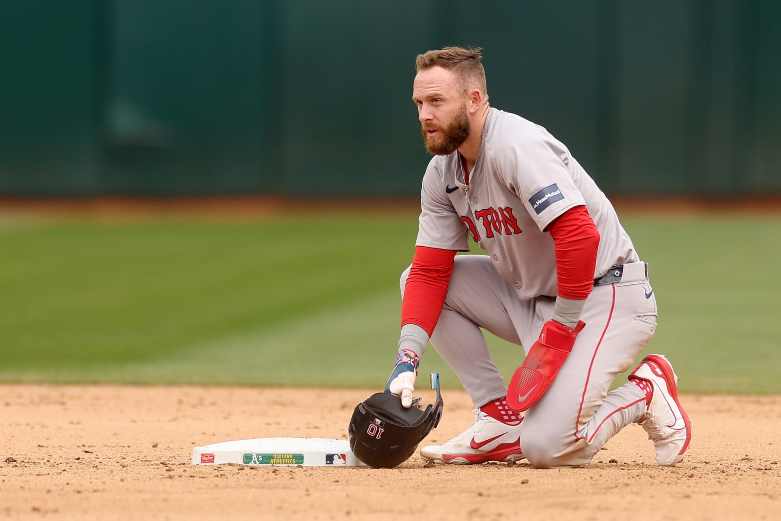 OAKLAND, CALIFORNIA - APRIL 03: Trevor Story #10 of the Boston Red Sox kneels by second base after he was forced out in a double play against the Oakland Athletics in the eighth inning at Oakland Coliseum on April 3, 2024 in Oakland, California. (Photo by Ezra Shaw/Getty Images)