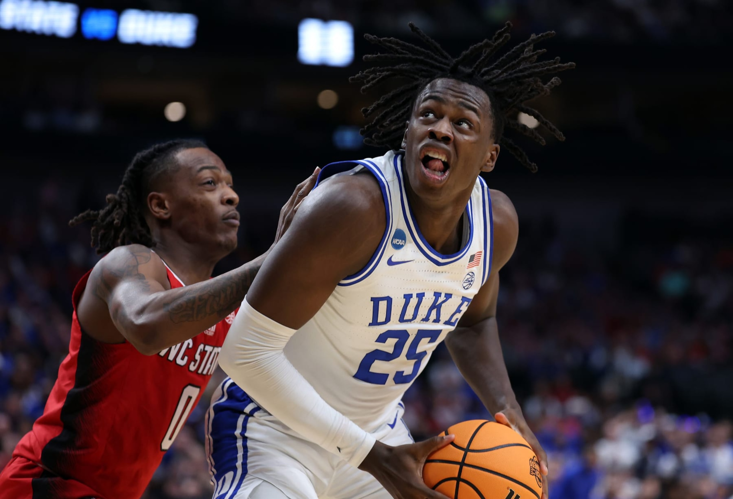 DALLAS, TEXAS - MARCH 31: Mark Mitchell #25 of the Duke Blue Devils controls the ball as DJ Horne #0 of the North Carolina State Wolfpack defends in the Elite 8 round of the NCAA Men's Basketball Tournament at American Airlines Center on March 31, 2024 in Dallas, Texas. (Photo by Patrick Smith/Getty Images) DALLAS, TEXAS - MARCH 31: Mark Mitchell #25 of the Duke Blue Devils controls the ball as DJ Horne #0 of the North Carolina State Wolfpack defends in the Elite 8 round of the NCAA Men's Basketball Tournament at American Airlines Center on March 31, 2024 in Dallas, Texas. (Photo by Patrick Smith/Getty Images)