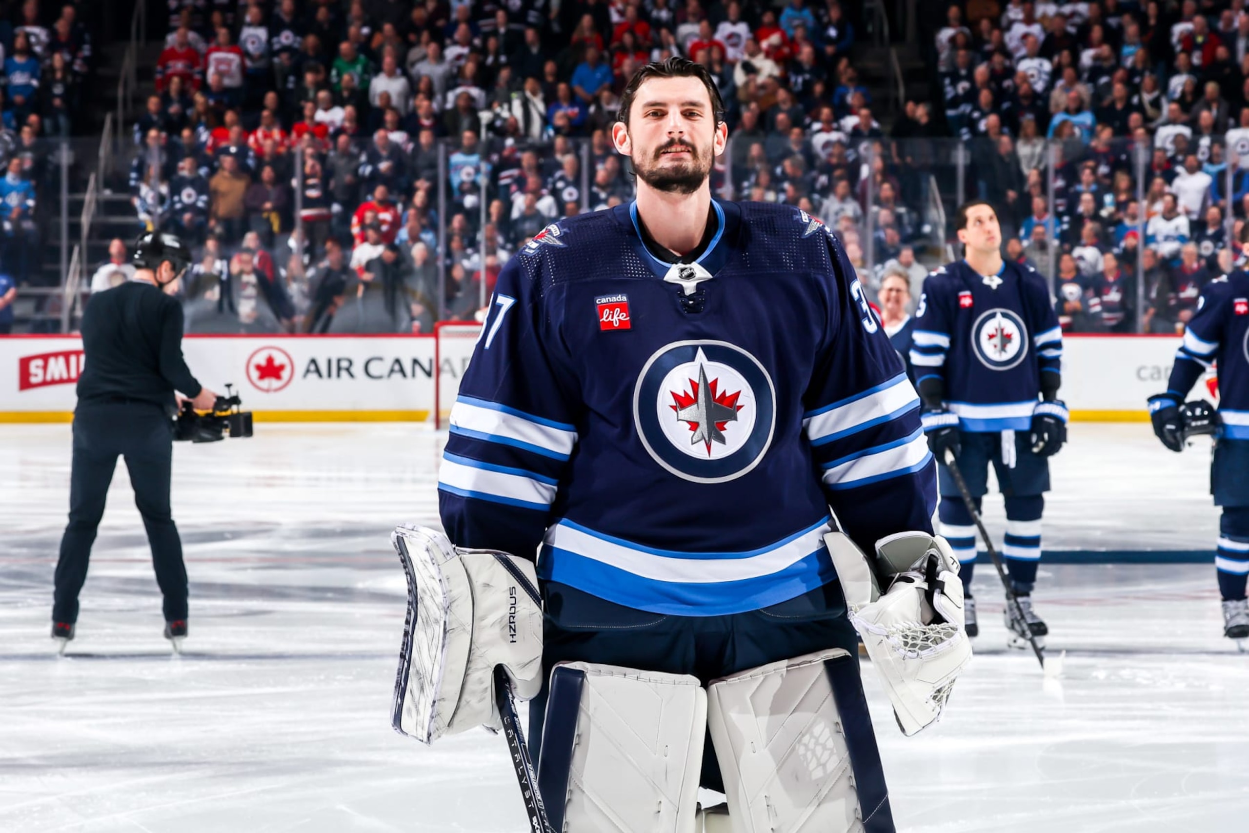WINNIPEG, CANADA - APRIL 4: Goaltender Connor Hellebuyck #37 of the Winnipeg Jets looks on from the ice prior to puck drop against the Calgary Flames at the Canada Life Centre on April 4, 2024 in Winnipeg, Manitoba, Canada. (Photo by Jonathan Kozub/NHLI via Getty Images)