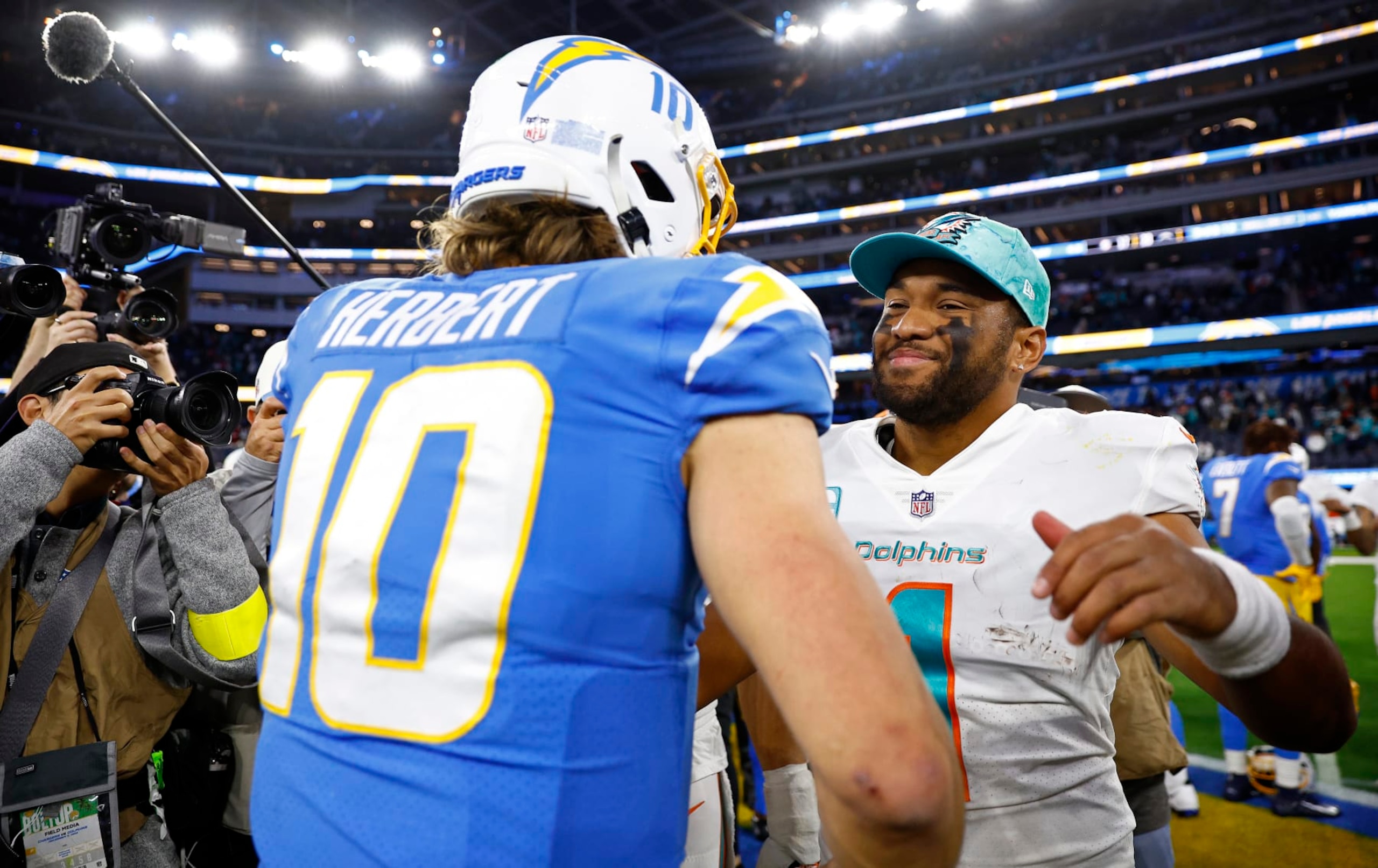 INGLEWOOD, CALIFORNIA - DECEMBER 11: Justin Herbert #10 of the Los Angeles Chargers hugs Tua Tagovailoa #1 of the Miami Dolphins during a game at SoFi Stadium on December 11, 2022 in Inglewood, California. (Photo by Ronald Martinez/Getty Images) INGLEWOOD, CALIFORNIA - DECEMBER 11: Justin Herbert #10 of the Los Angeles Chargers hugs Tua Tagovailoa #1 of the Miami Dolphins during a game at SoFi Stadium on December 11, 2022 in Inglewood, California. (Photo by Ronald Martinez/Getty Images)