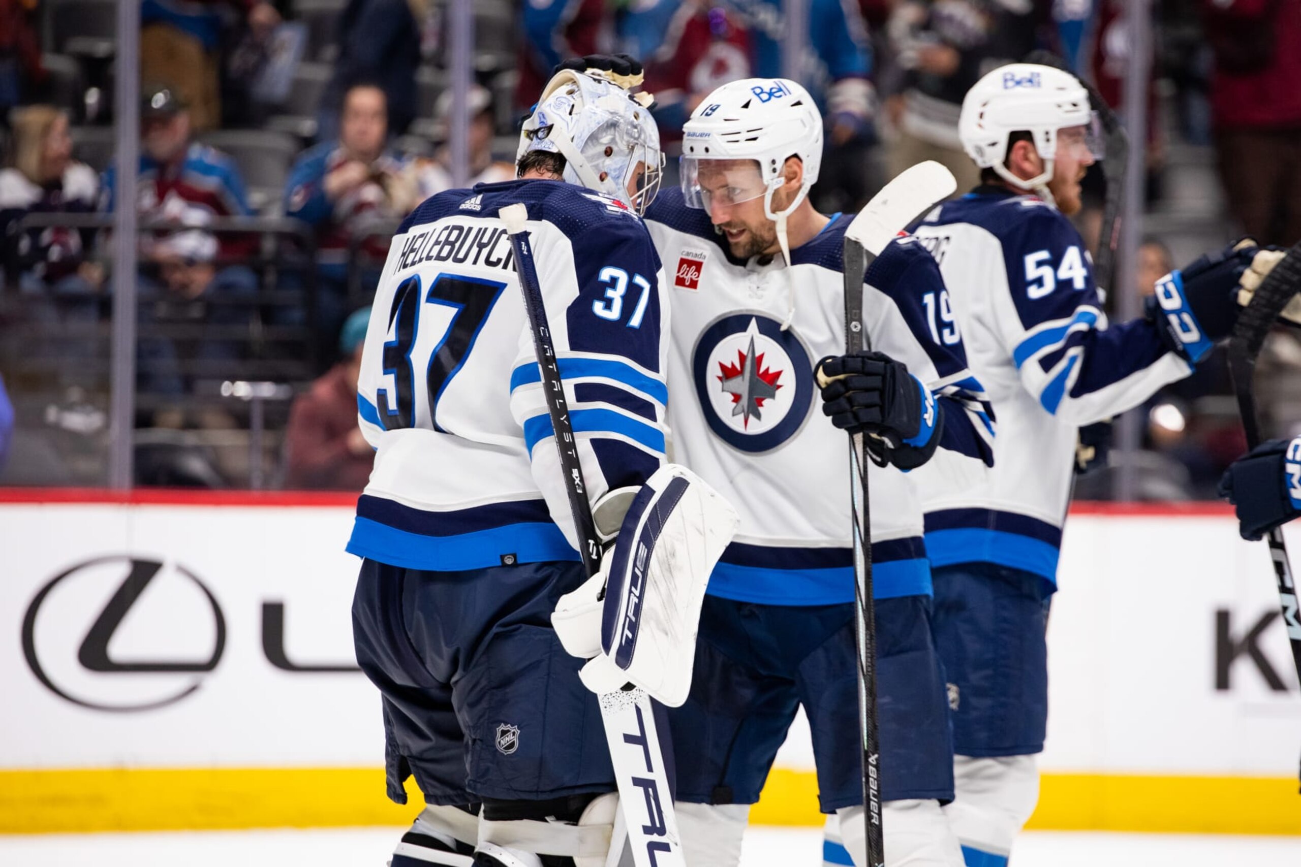 DENVER, COLORADO - APRIL 13: Connor Hellebuyck #37 and David Gustafsson #19 of the Winnipeg Jets hug in celebration after beating the Colorado Avalanche 7-0 at Ball Arena on April 13, 2024 in Denver, Colorado. (Photo by Ashley Potts/NHLI via Getty Images)