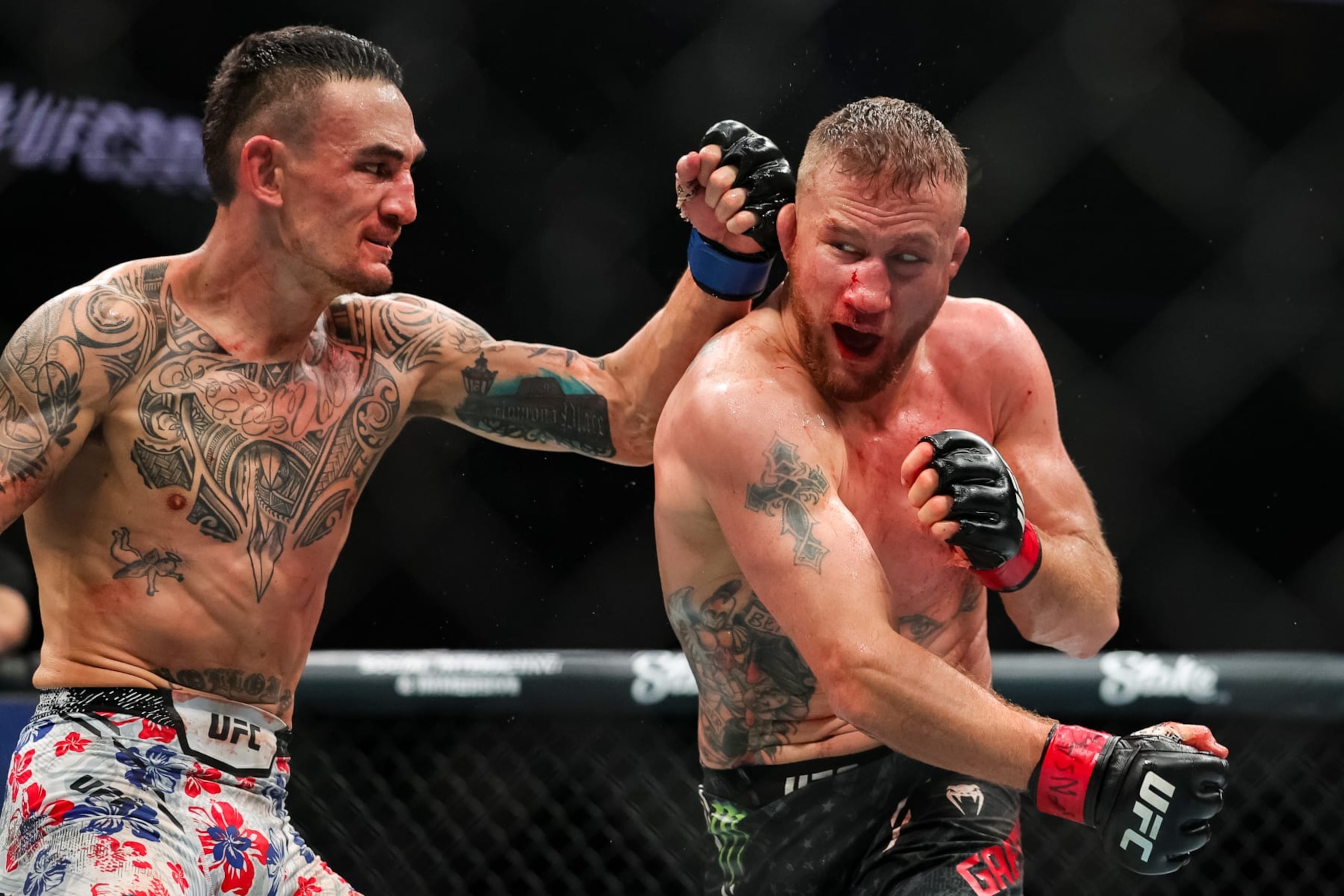 LAS VEGAS, NEVADA - APRIL 13: Justin Gaethje and Max Holloway exchange strikes during their BMF title fight at T-Mobile Arena on April 13, 2024 in Las Vegas, Nevada. (Photo by Carmen Mandato/Getty Images)