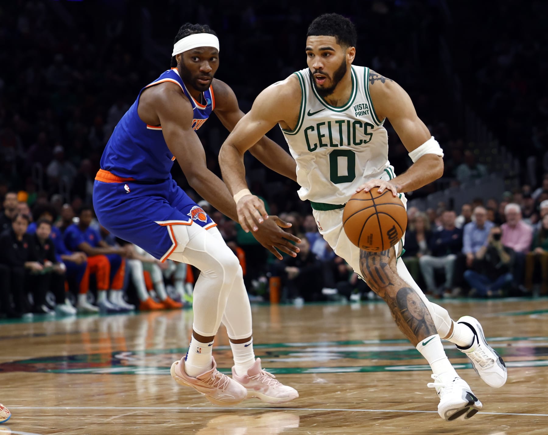 Boston, MA - April 11: Boston Celtics forward Jayson Tatum drives past New York Knicks forward Precious Achiuwa in the second quarter. (Photo by Danielle Parhizkaran/The Boston Globe via Getty Images)