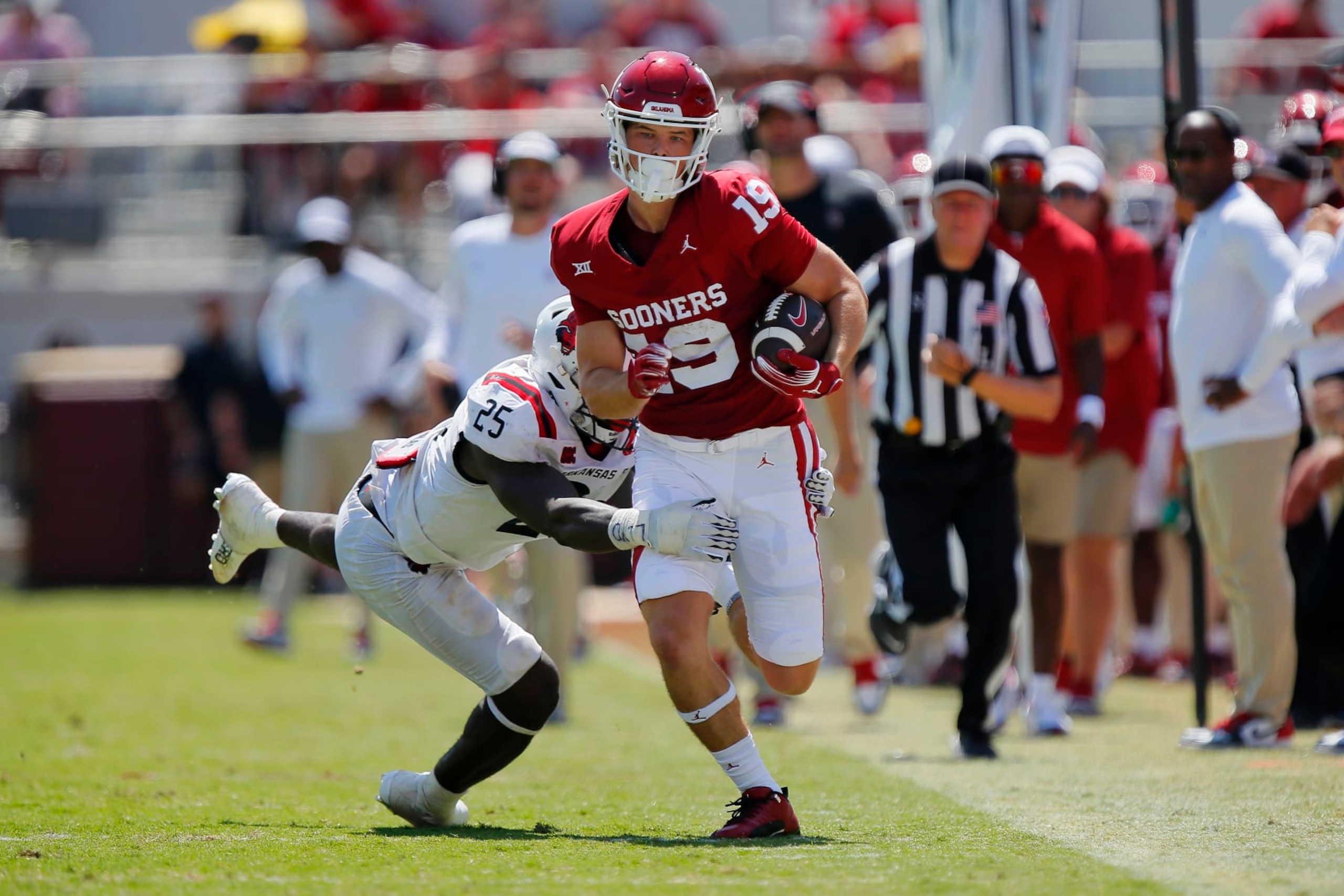 NORMAN, OKLAHOMA - SEPTEMBER 2:  Tight end Kade McIntyre #19 of the Oklahoma Sooners runs down the sideline for a 26-yard catch and run against defensive end Keyron Crawford #25 of the Arkansas State Red Wolves in the third quarter at Gaylord Family Oklahoma Memorial Stadium on September 2, 2023 in Norman, Oklahoma.  Oklahoma won 73-0. (Photo by Brian Bahr/Getty Images)
