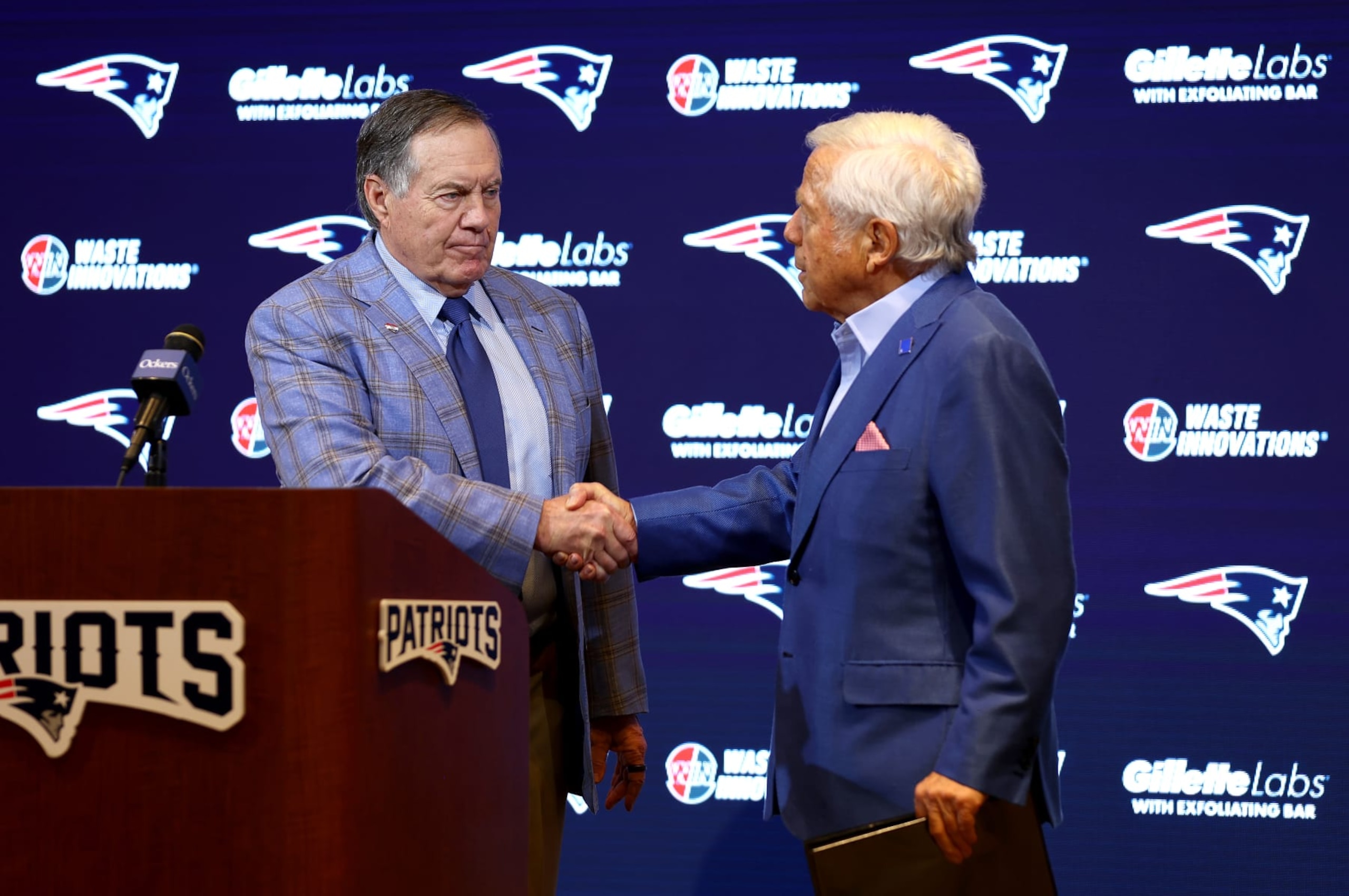 FOXBOROUGH, MASSACHUSETTS - JANUARY 11: Head coach Bill Belichick (L) of the New England Patriots shakes hands with owner Robert Kraft (R) during a press conference at Gillette Stadium on January 11, 2024 in Foxborough, Massachusetts. Belichick announced he is stepping down as head coach after 24 seasons with the team. (Photo by Maddie Meyer/Getty Images)