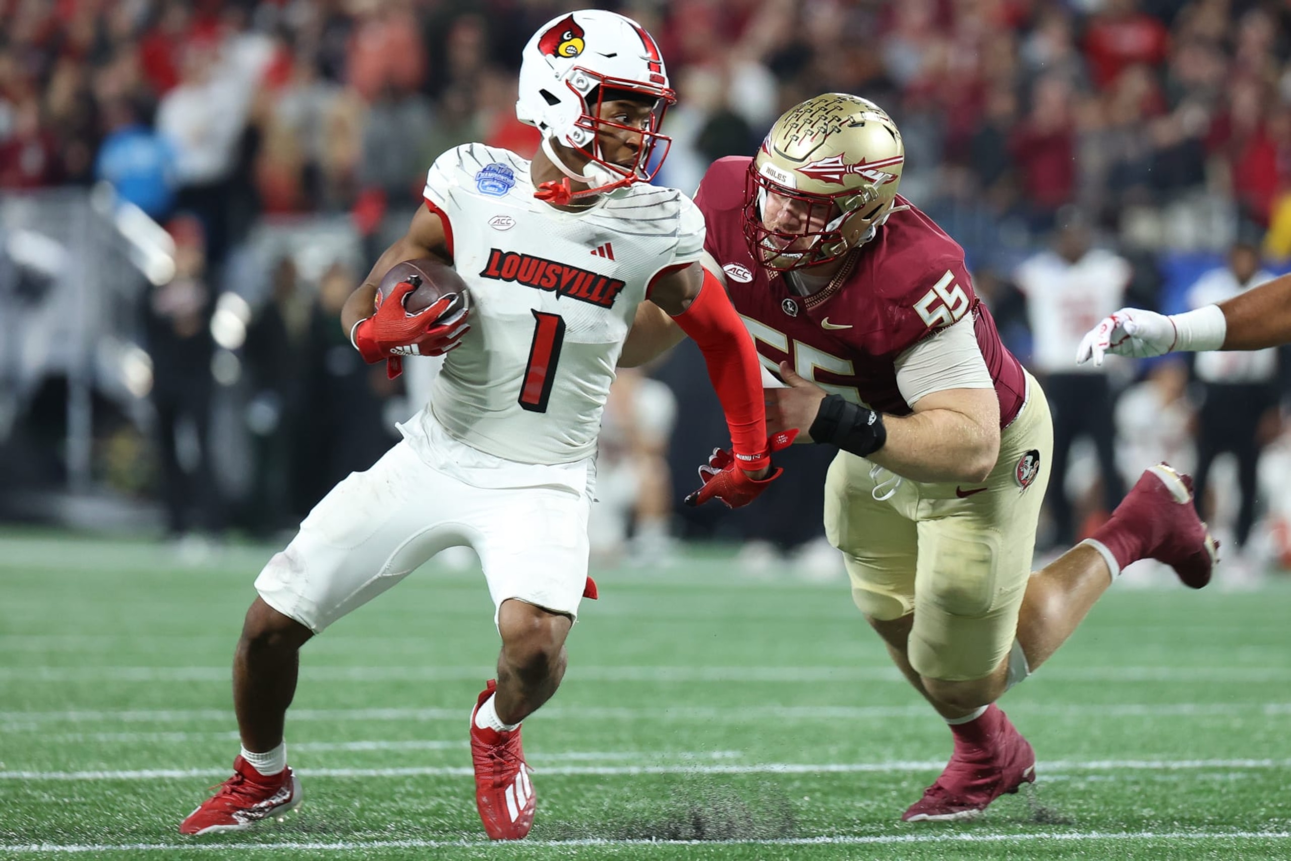 CHARLOTTE, NORTH CAROLINA - DECEMBER 2: Jamari Thrash #1 of the Louisville Cardinals runs the ball against Braden Fiske #55 of the Florida State Seminoles during the ACC Championship at Bank of America Stadium on December 2, 2023 in Charlotte, North Carolina. (Photo by Isaiah Vazquez/Getty Images)