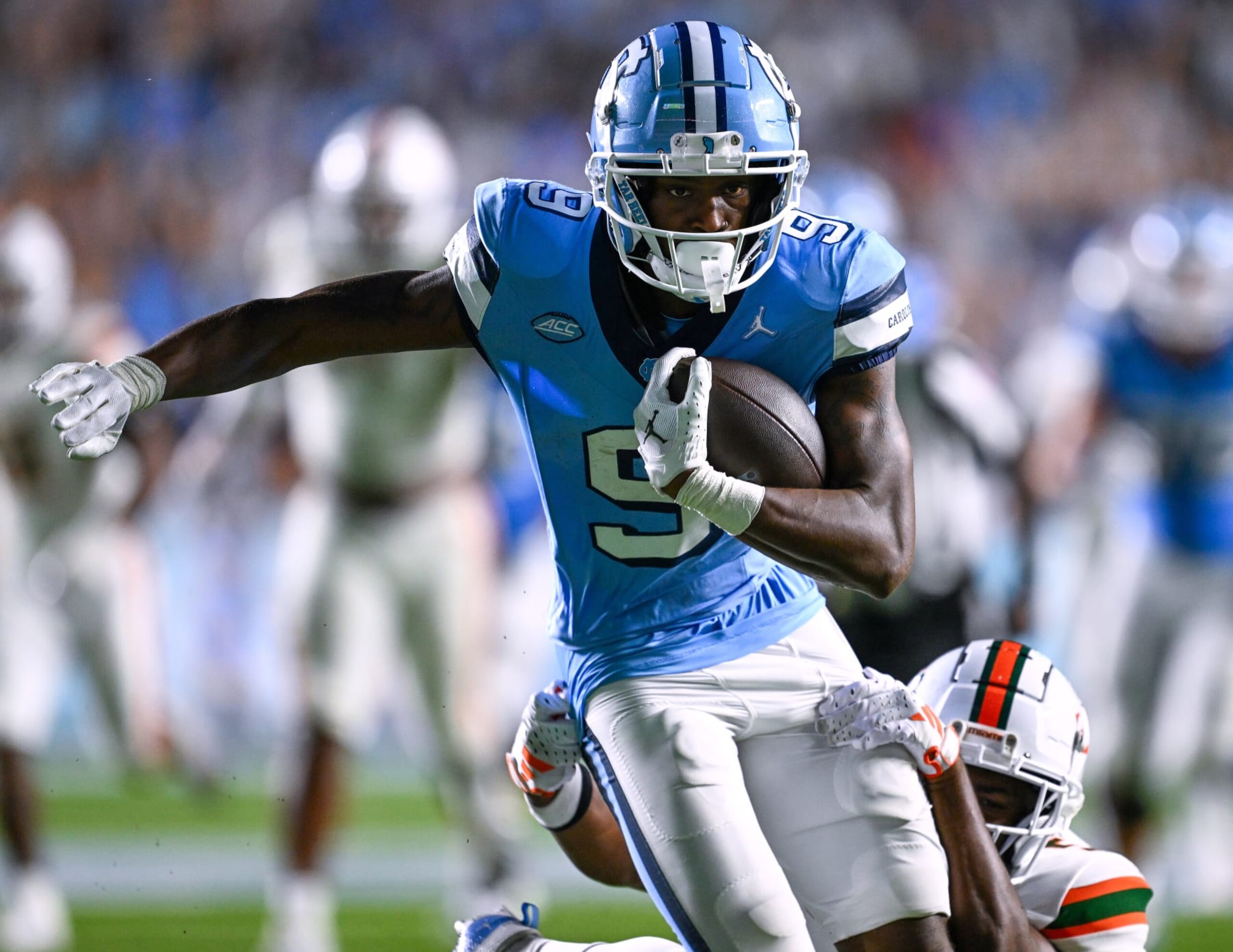 CHAPEL HILL, NORTH CAROLINA - OCTOBER 14: Devontez Walker #9 of the North Carolina Tar Heels breaks away from  Kamren Kinchens #5 of the Miami Hurricanes for a touchdown during the second half of their game at Kenan Memorial Stadium on October 14, 2023 in Chapel Hill, North Carolina. The Tar Heels won 41-31. (Photo by Grant Halverson/Getty Images)