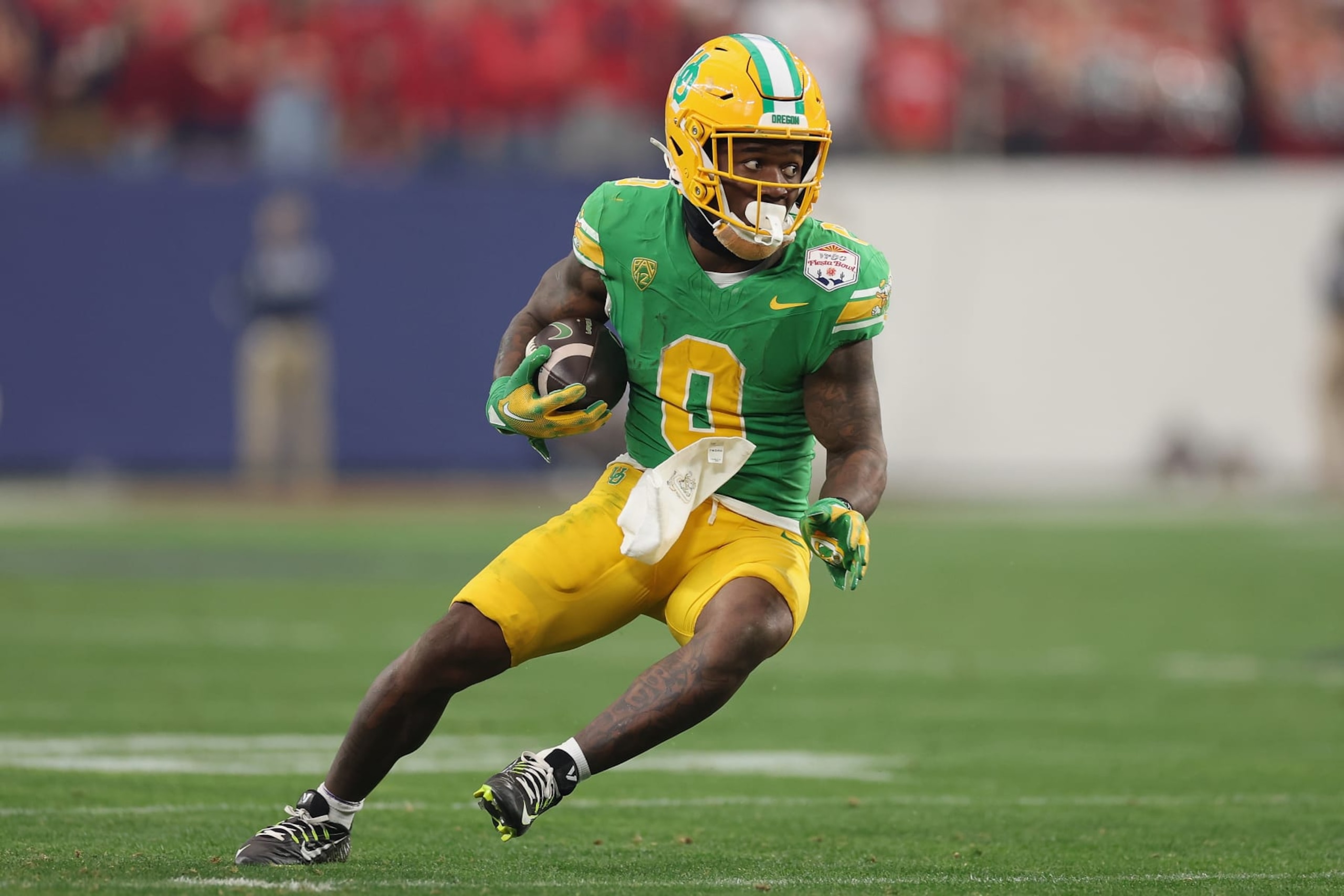 GLENDALE, ARIZONA - JANUARY 01: Running back Bucky Irving #0 of the Oregon Ducks rushes the football during the second half of the Fiesta Bowl at State Farm Stadium on January 01, 2024 in Glendale, Arizona. The Ducks defeated the Flames 45-6. (Photo by Christian Petersen/Getty Images)