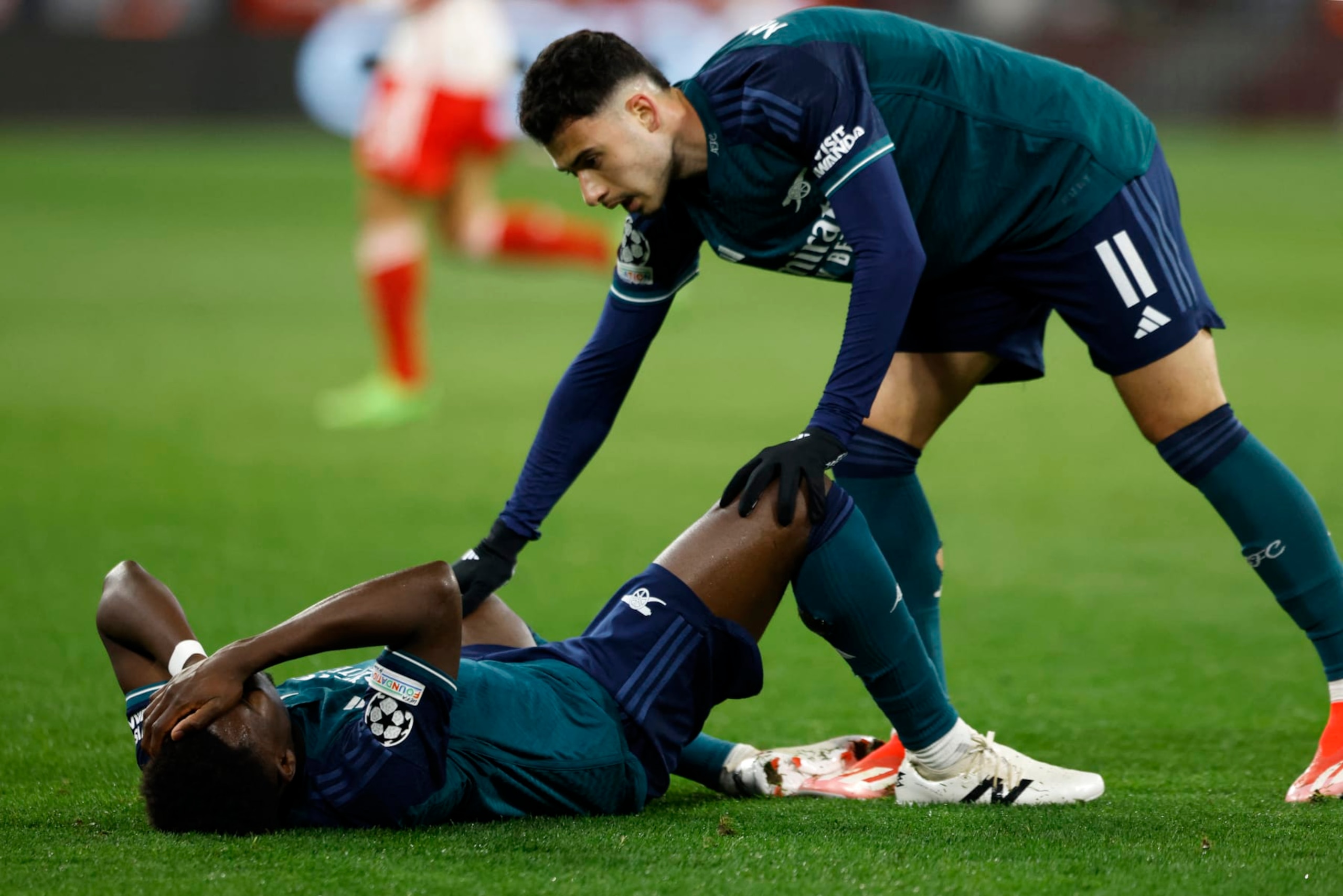 Arsenal's Brazilian midfielder #11 Gabriel Martinelli (R) reacts as Arsenal's English midfielder #07 Bukayo Saka lies on the pitch after having been hit with the ball on the head during the UEFA Champions League quarter-final second leg football match between FC Bayern Munich and Arsenal FC in Munich, southern Germany on April 17, 2024. (Photo by Michaela STACHE / AFP) (Photo by MICHAELA STACHE/AFP via Getty Images)
