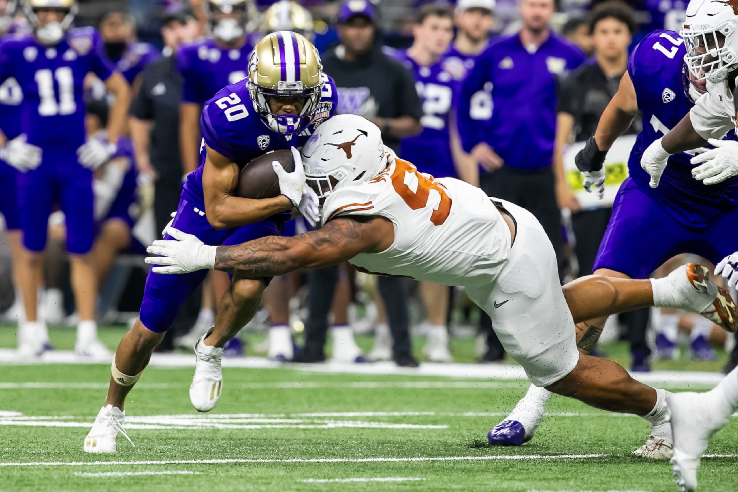 NEW ORLEANS, LA - JANUARY 01: Texas defensive lineman Byron Murphy II (90) takes down Washington running back Tybo Rogers (20) during the Allstate Sugar Bowl playoff game between the Texas Longhorns and the Washington Huskies on Monday, January 1, 2024 at Caesars Superdome in New Orleans, LA.  (Photo by Nick Tre. Smith/Icon Sportswire via Getty Images)