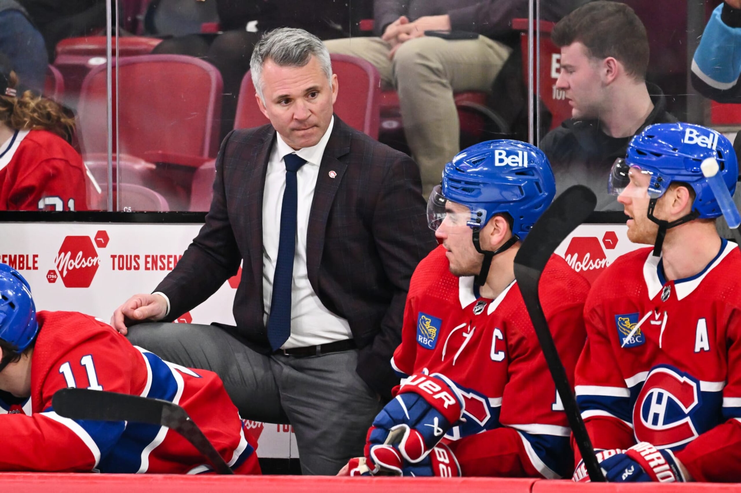 MONTREAL, CANADA - MARCH 30:  Head coach of the Montreal Canadiens Martin St-Louis, looks at Nick Suzuki #14 from the bench during the third period against the Carolina Hurricanes at the Bell Centre on March 30, 2024 in Montreal, Quebec, Canada.  The Carolina Hurricanes defeated the Montreal Canadiens 3-0.  (Photo by Minas Panagiotakis/Getty Images)