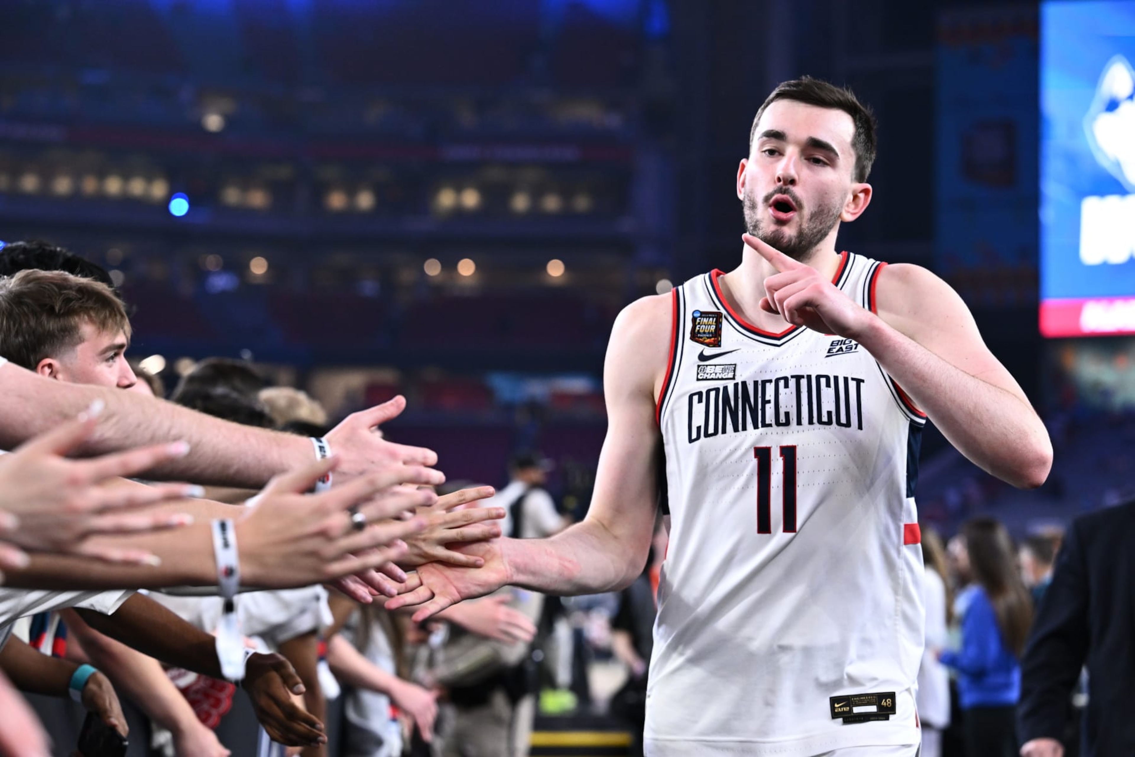 GLENDALE, ARIZONA - APRIL 06: Alex Karaban #11 of the Connecticut Huskies high fives fans after defeating the Alabama Crimson Tide in the NCAA Men’s Basketball Tournament Final Four semifinal game at State Farm Stadium on April 06, 2024 in Glendale, Arizona. (Photo by Brett Wilhelm/NCAA Photos via Getty Images) GLENDALE, ARIZONA - APRIL 06: Alex Karaban #11 of the Connecticut Huskies high fives fans after defeating the Alabama Crimson Tide in the NCAA Men’s Basketball Tournament Final Four semifinal game at State Farm Stadium on April 06, 2024 in Glendale, Arizona. (Photo by Brett Wilhelm/NCAA Photos via Getty Images)