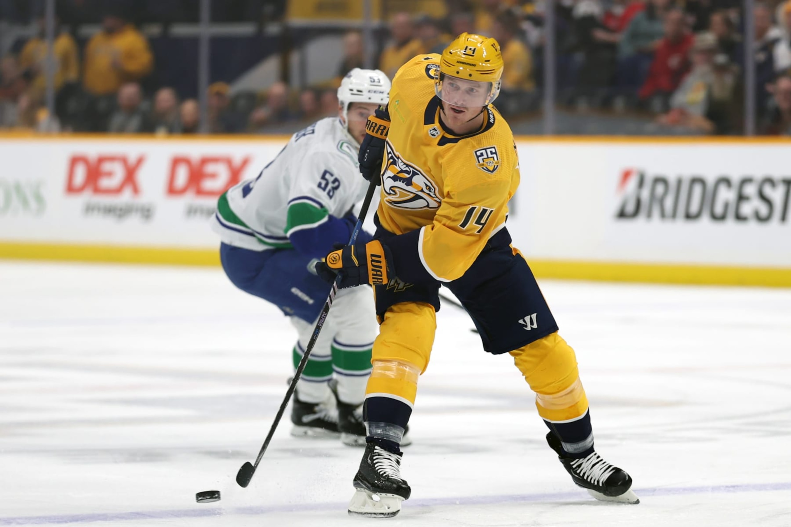 NASHVILLE, TENNESSEE - DECEMBER 19: Gustav Nyquist #14 of the Nashville Predators looks to pass the puck with Teddy Blueger #53 of the Vancouver Canucks defending at Bridgestone Arena on December 19, 2023 in Nashville, Tennessee. The Vancouver Canucks won the game 5-2. (Photo by Donald Page/Getty Images)