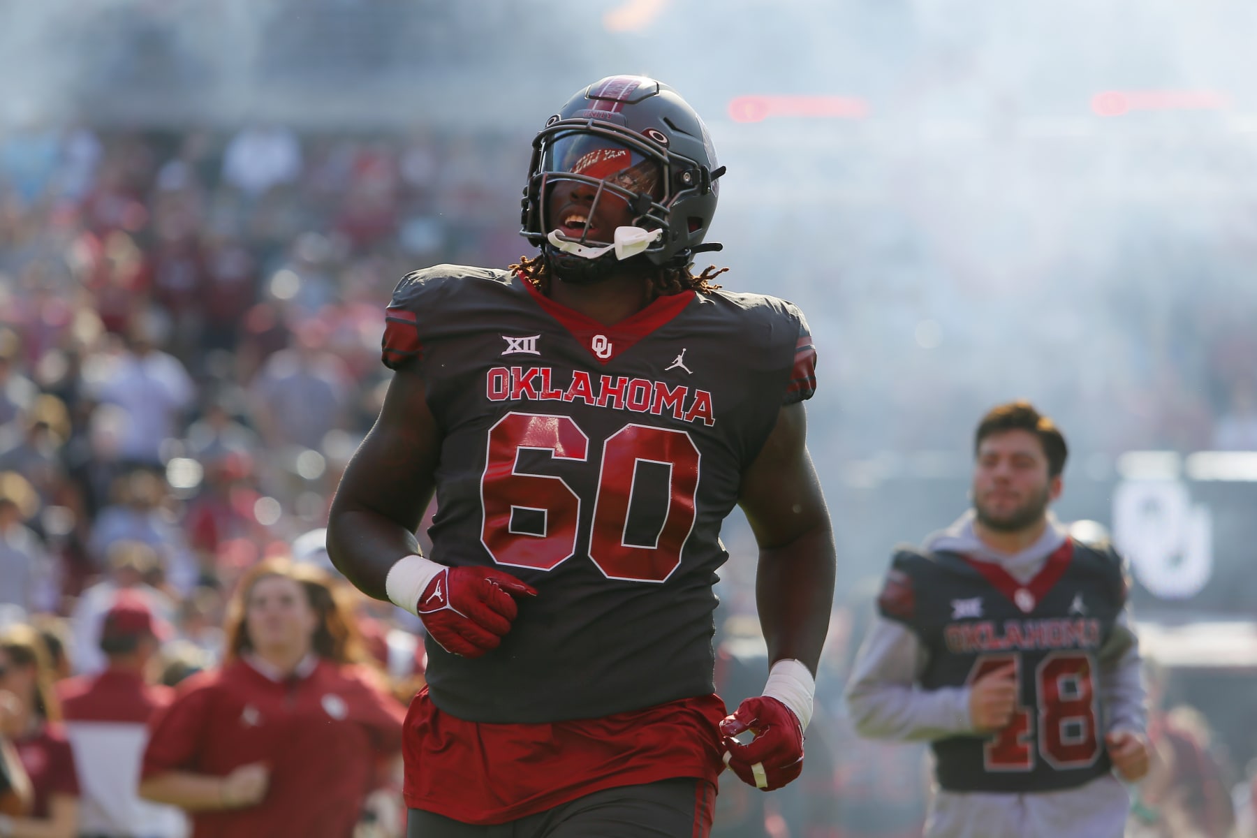 NORMAN, OK - OCTOBER 15:  Left tackle Tyler Guyton #60 of the Oklahoma Sooners looks up at a banner as he runs onto the field for a game against the Kansas Jayhawks at Gaylord Family Oklahoma Memorial Stadium on October 15, 2022 in Norman, Oklahoma.  Oklahoma won 52-42.  (Photo by Brian Bahr/Getty Images)