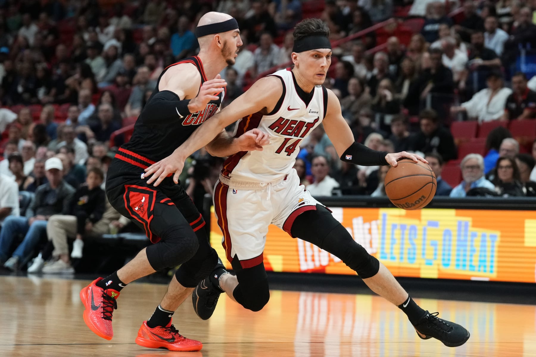 MIAMI, FLORIDA - APRIL 19: Tyler Herro #14 of the Miami Heat dribbles the ball against Alex Caruso #6 of the Chicago Bulls in the first quarter during the Play-In Tournament at Kaseya Center on April 19, 2024 in Miami, Florida. NOTE TO USER: User expressly acknowledges and agrees that, by downloading and or using this photograph, User is consenting to the terms and conditions of the Getty Images License Agreement. (Photo by Rich Storry/Getty Images)