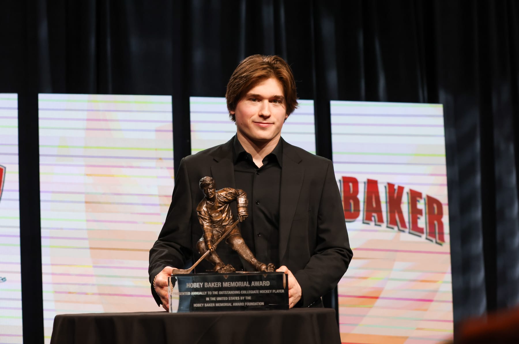 Boston University's Macklin Celebrini poses with the Hobey Baker Memorial Award.