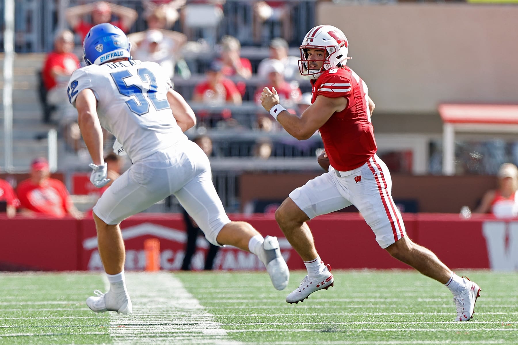 MADISON, WISCONSIN - SEPTEMBER 02: Tanner Mordecai #8 of the Wisconsin Badgers takes off running trying to avoid the rush from Shaun Dolac #52 of the Buffalo Bulls at Camp Randall Stadium on September 02, 2023 in Madison, Wisconsin. (Photo by John Fisher/Getty Images)
