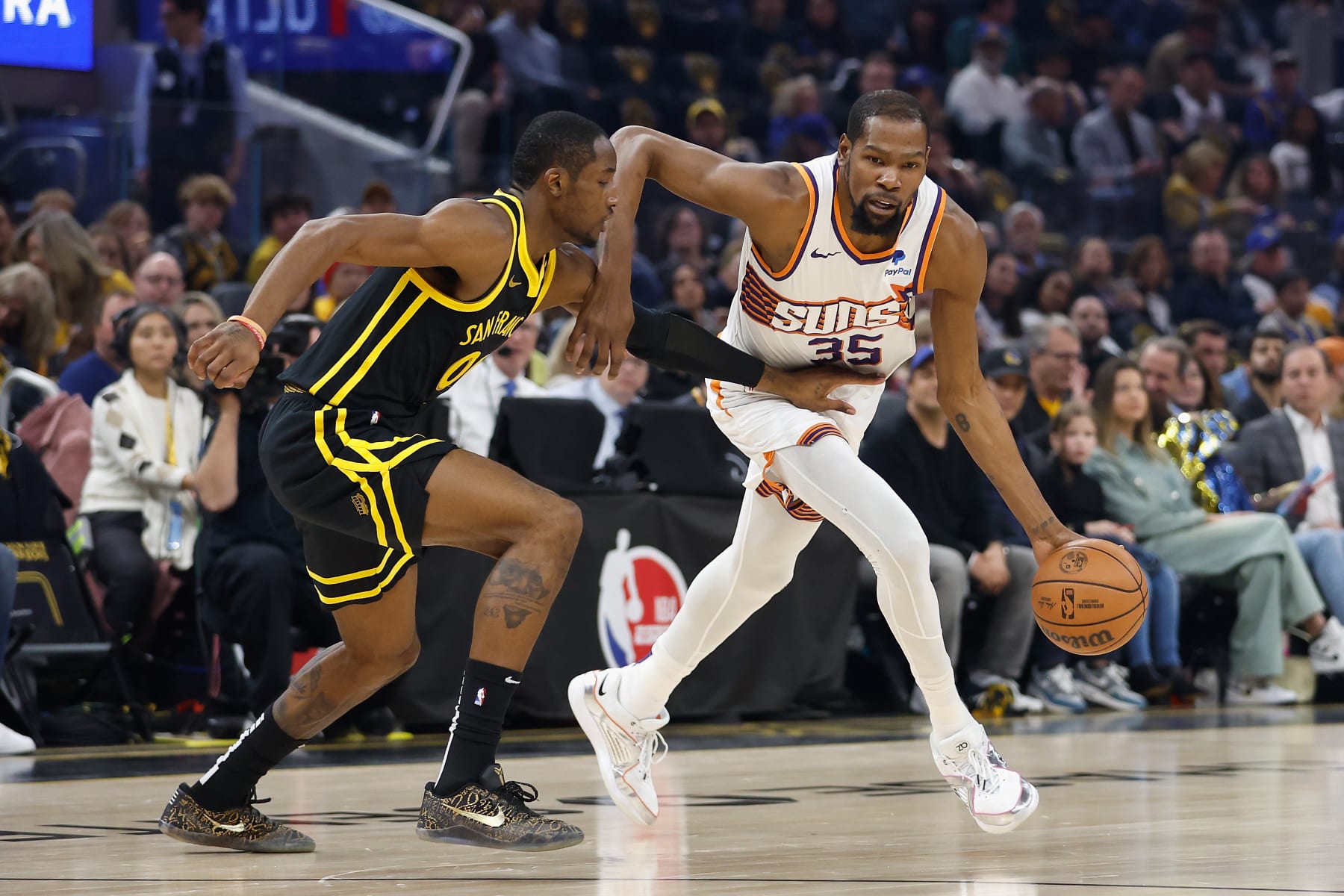 SAN FRANCISCO, CALIFORNIA - FEBRUARY 10: Kevin Durant #35 of the Phoenix Suns is guarded by Jonathan Kuminga #00 of the Golden State Warriors in the first quarter at Chase Center on February 10, 2024 in San Francisco, California. NOTE TO USER: User expressly acknowledges and agrees that, by downloading and or using this photograph, User is consenting to the terms and conditions of the Getty Images License Agreement. (Photo by Lachlan Cunningham/Getty Images)