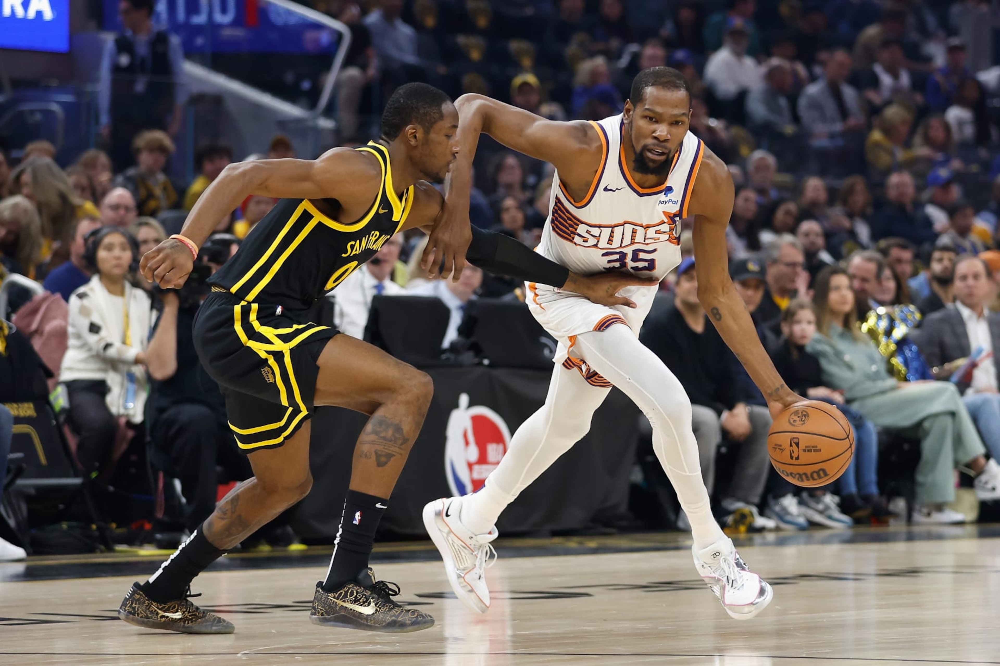 SAN FRANCISCO, CALIFORNIA - FEBRUARY 10: Kevin Durant #35 of the Phoenix Suns is guarded by Jonathan Kuminga #00 of the Golden State Warriors in the first quarter at Chase Center on February 10, 2024 in San Francisco, California. NOTE TO USER: User expressly acknowledges and agrees that, by downloading and or using this photograph, User is consenting to the terms and conditions of the Getty Images License Agreement. (Photo by Lachlan Cunningham/Getty Images)