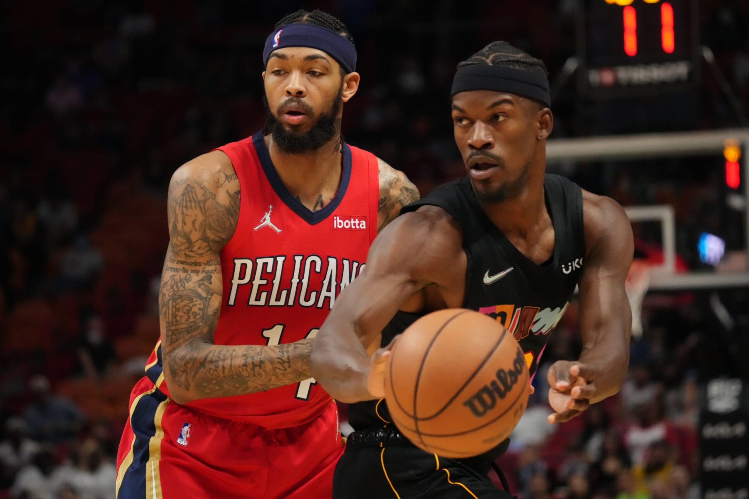 MIAMI, FLORIDA - NOVEMBER 17: Jimmy Butler #22 of the Miami Heat passes the ball against Brandon Ingram #14 of the New Orleans Pelicans during the first half at FTX Arena on November 17, 2021 in Miami, Florida. NOTE TO USER: User expressly acknowledges and agrees that, by downloading and or using this photograph, User is consenting to the terms and conditions of the Getty Images License Agreement. (Photo by Mark Brown/Getty Images)