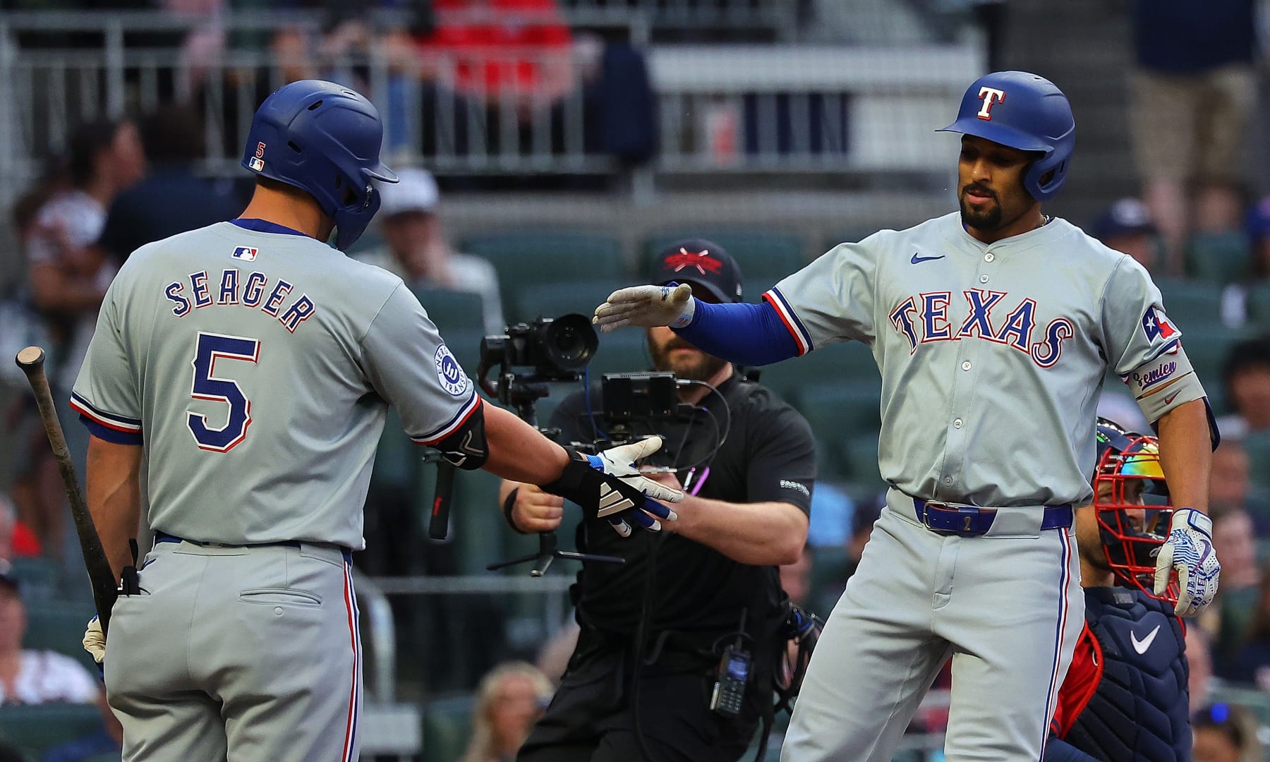 ATLANTA, GEORGIA - APRIL 19:  Marcus Semien #2 of the Texas Rangers reacts with Corey Seager #5 after hitting a solo homer to lead off the first inning against the Atlanta Braves at Truist Park on April 19, 2024 in Atlanta, Georgia. (Photo by Kevin C. Cox/Getty Images)