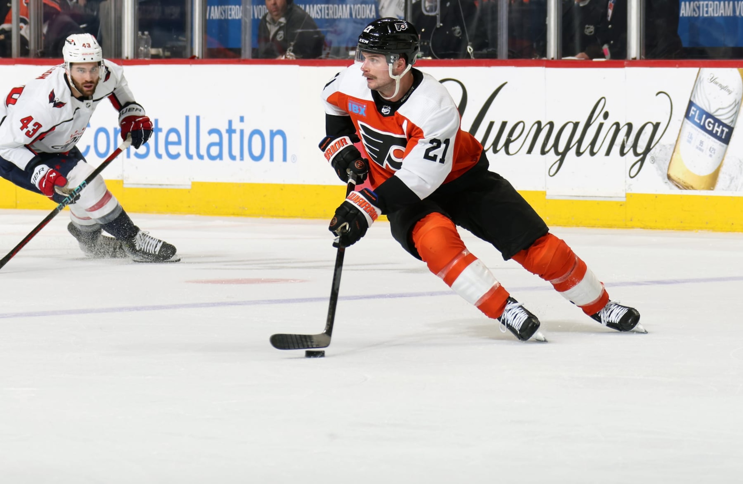 PHILADELPHIA, PENNSYLVANIA - APRIL 16:  Scott Laughton #21 of the Philadelphia Flyers skates the puck against Tom Wilson #43 of the Washington Capitals at the Wells Fargo Center on April 16, 2024 in Philadelphia, Pennsylvania.  (Photo by Len Redkoles/NHLI via Getty Images)