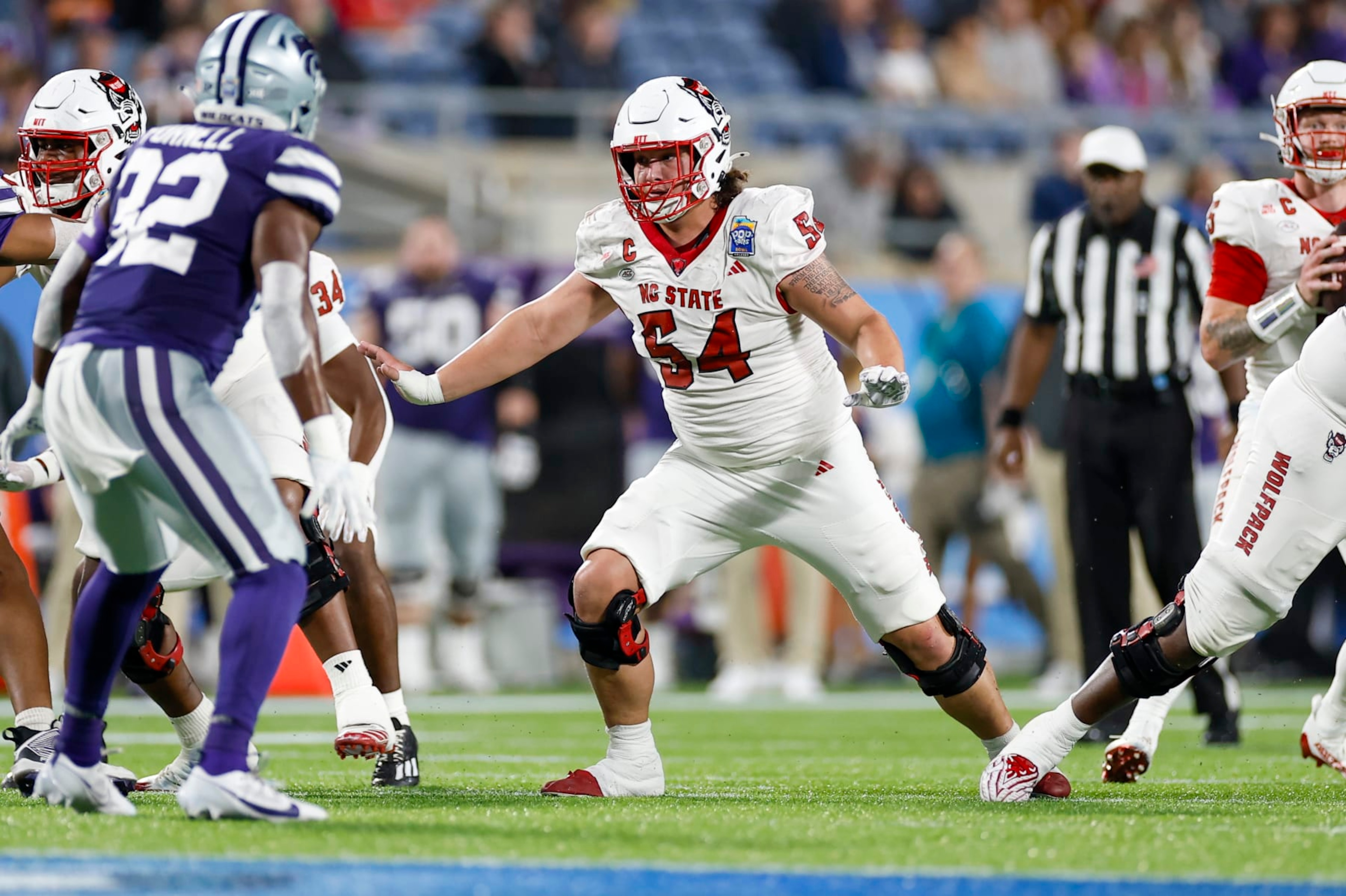 ORLANDO, FL - DECEMBER 28: North Carolina State Wolfpack offensive lineman Dylan McMahon (54) /blocls during the game between the North Carolina State Wolfpack and the Kansas State Wildcats on December 28, 2023 at Camping World Stadium in Orlando, Fl. (Photo by David Rosenblum/Icon Sportswire via Getty Images)