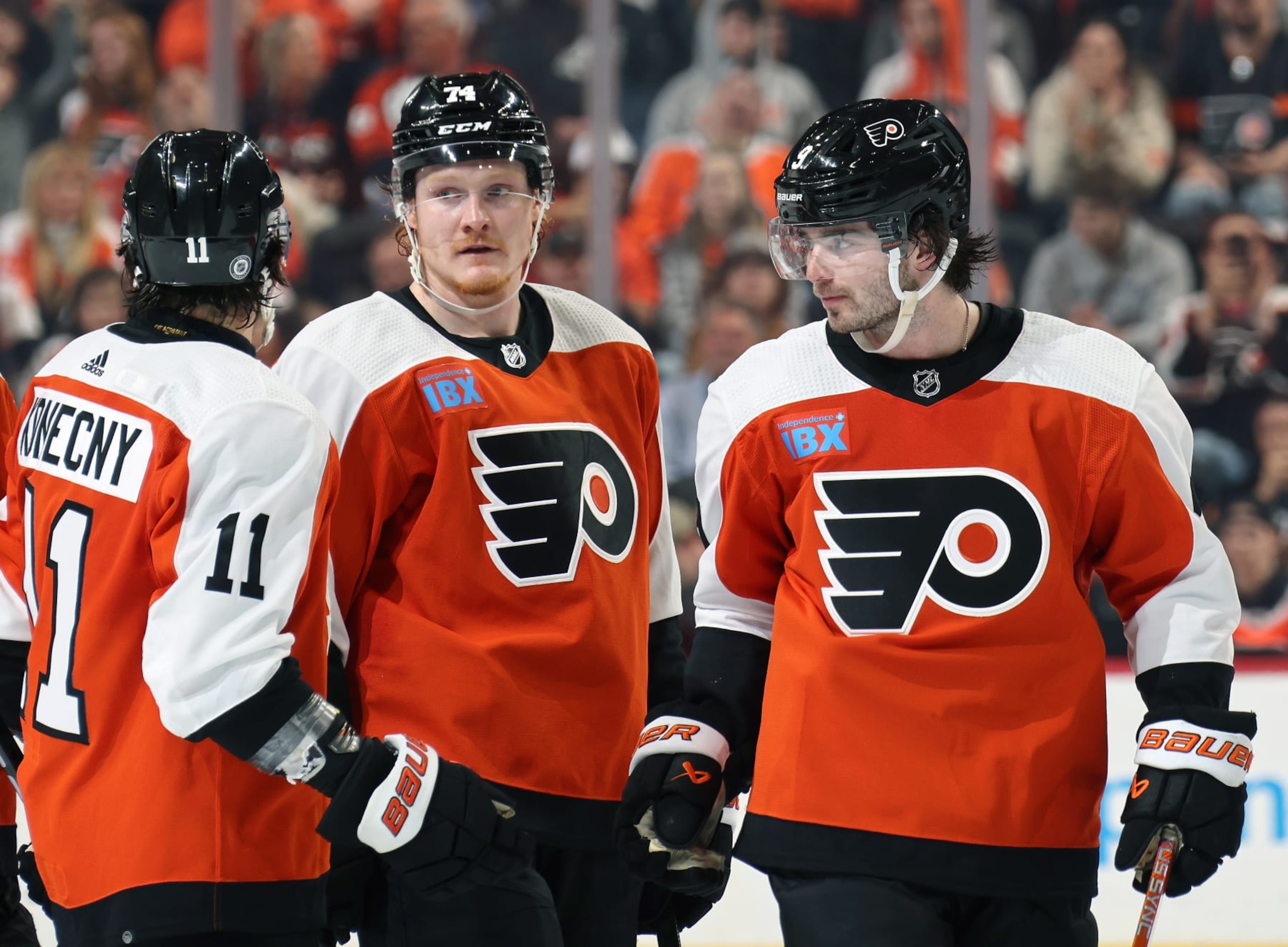 PHILADELPHIA, PENNSYLVANIA - APRIL 16:  Travis Konecny #11, Owen Tippett #74 and Jamie Drysdale #9 of the Philadelphia Flyers gather during a stoppage in play against the Washington Capitals at the Wells Fargo Center on April 16, 2024 in Philadelphia, Pennsylvania.  (Photo by Len Redkoles/NHLI via Getty Images)