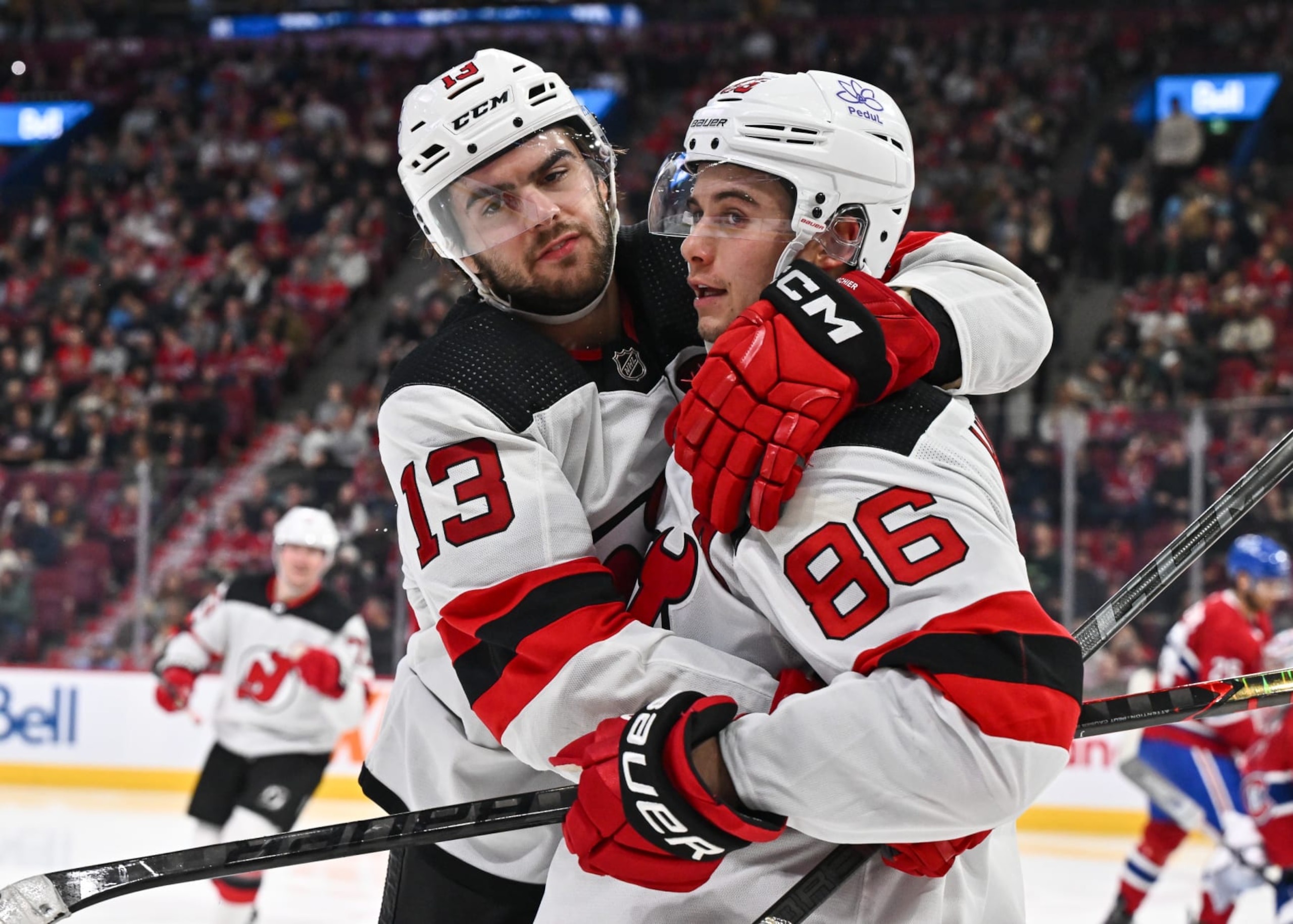 MONTREAL, CANADA - OCTOBER 24:  Nico Hischier #13 of the New Jersey Devils (L) celebrates his goal with teammate Jack Hughes #86 (R) during the third period at the Bell Centre on October 24, 2023 in Montreal, Quebec, Canada.  The New Jersey Devils defeated the Montreal Canadiens 5-2.  (Photo by Minas Panagiotakis/Getty Images)