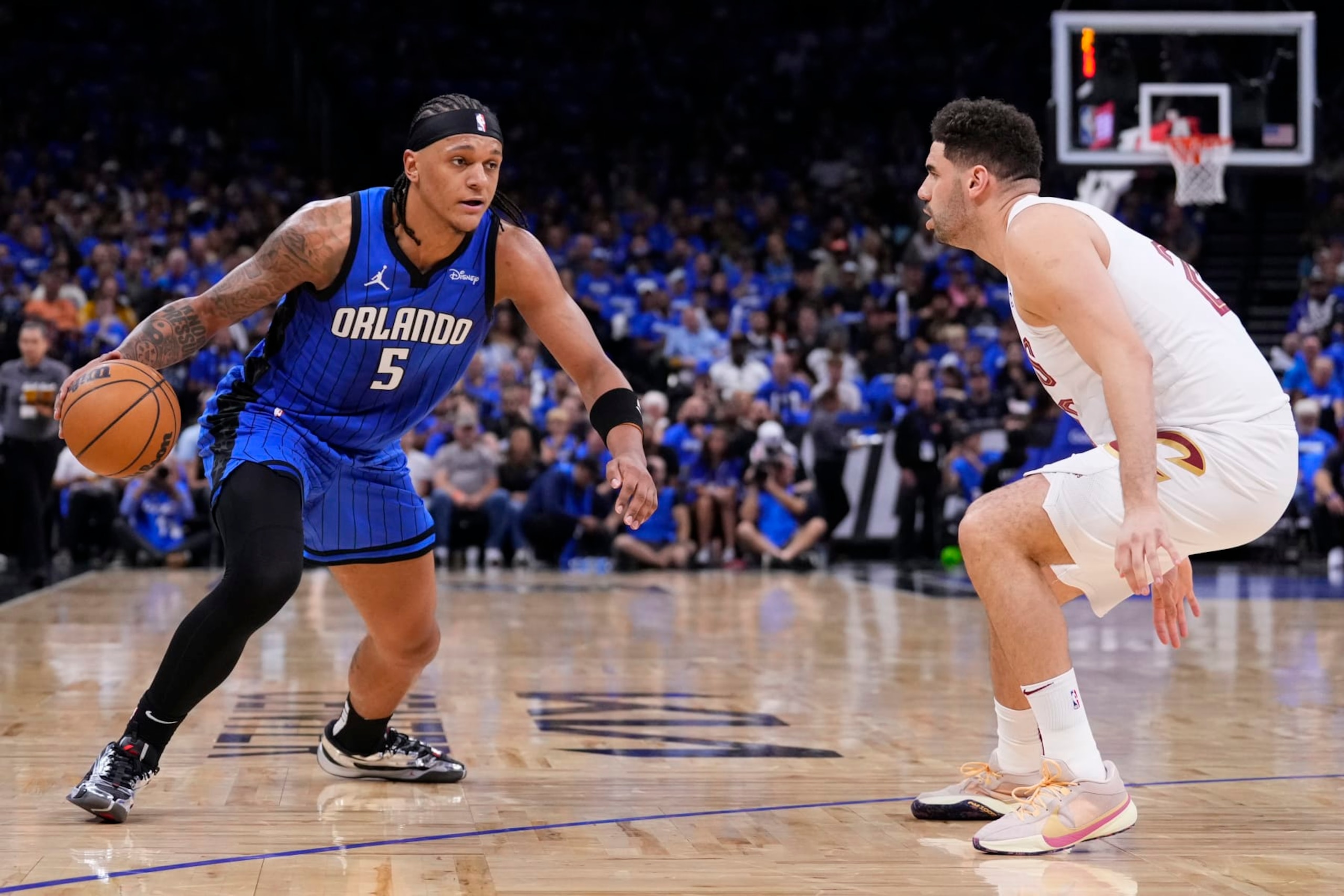 ORLANDO, FLORIDA - APRIL 25: Paolo Banchero #5 of the Orlando Magic dribbles the ball against Georges Niang #20 of the Cleveland Cavaliers during the first quarter of game three of the Eastern Conference First Round Playoffs at Kia Center on April 25, 2024 in Orlando, Florida. NOTE TO USER: User expressly acknowledges and agrees that, by downloading and or using this photograph, User is consenting to the terms and conditions of the Getty Images License Agreement. (Photo by Rich Storry/Getty Images)